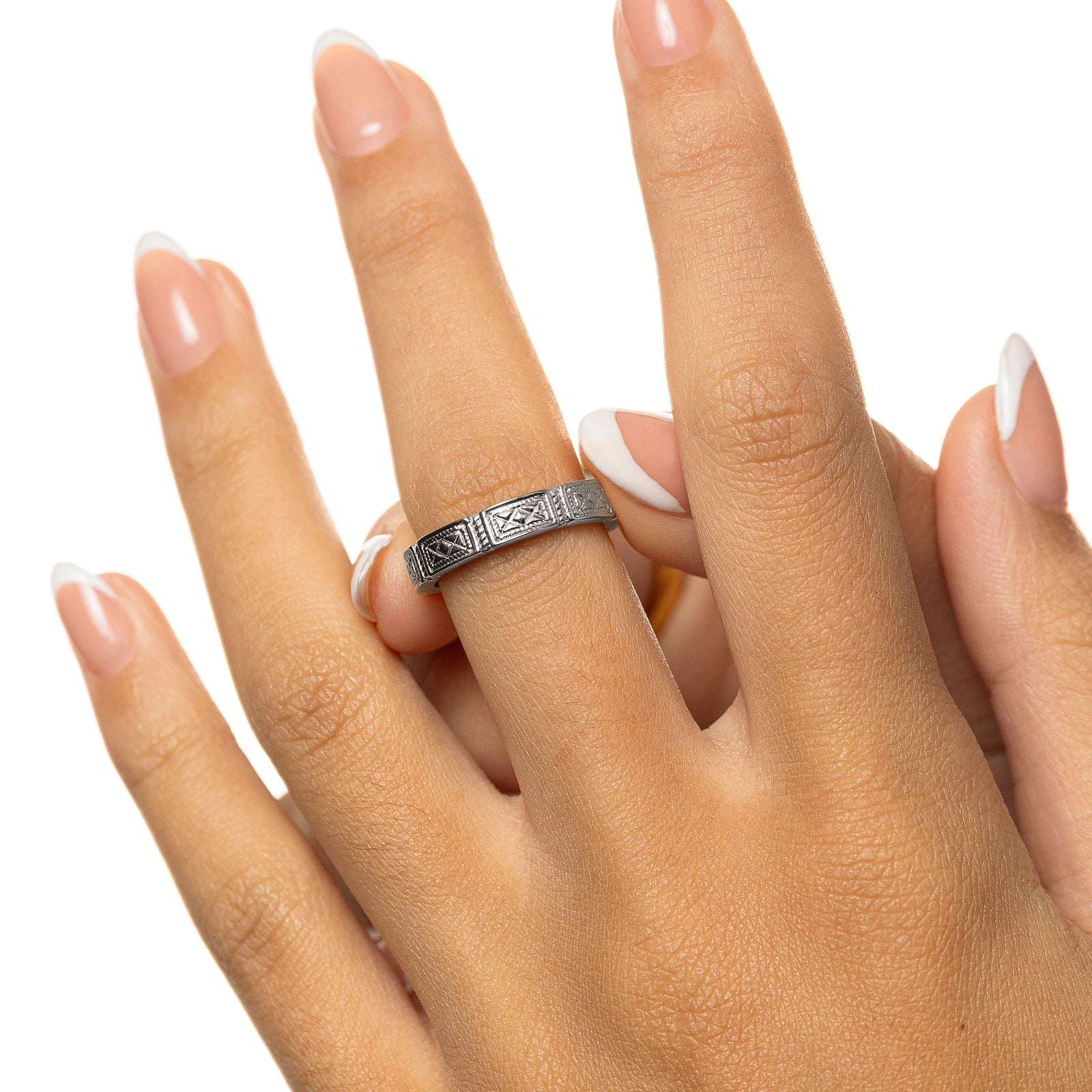 Woman wearing a silver Damascus Tile Ring with engraved tile-style patterns on her finger, shown in a close-up hand shot.