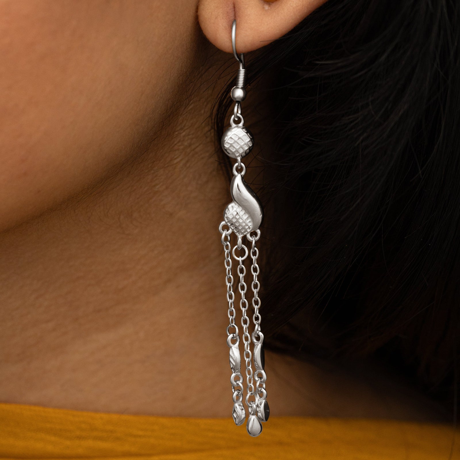 Close up photo of the silver Dancing Paisley Earring as worn by the model.