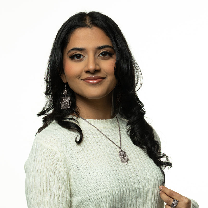 Woman wearing a silver dancing kite necklace pimage_ styled with a white sweater.