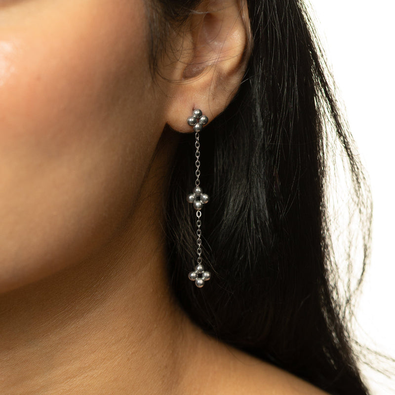 Woman wearing the silver Dangling Henna Earrings close to the ear.