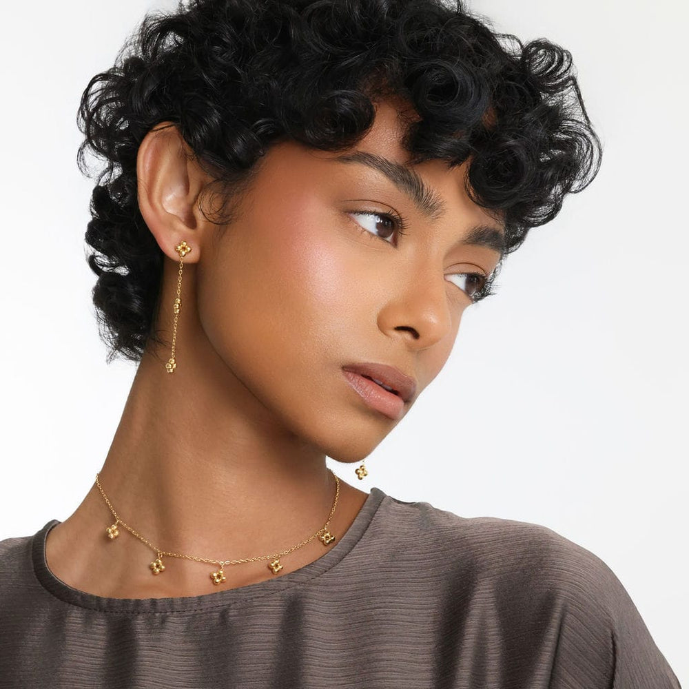 Photo of the model leaning their head slightly to the side to show the gold Dangling Henna Earrings.