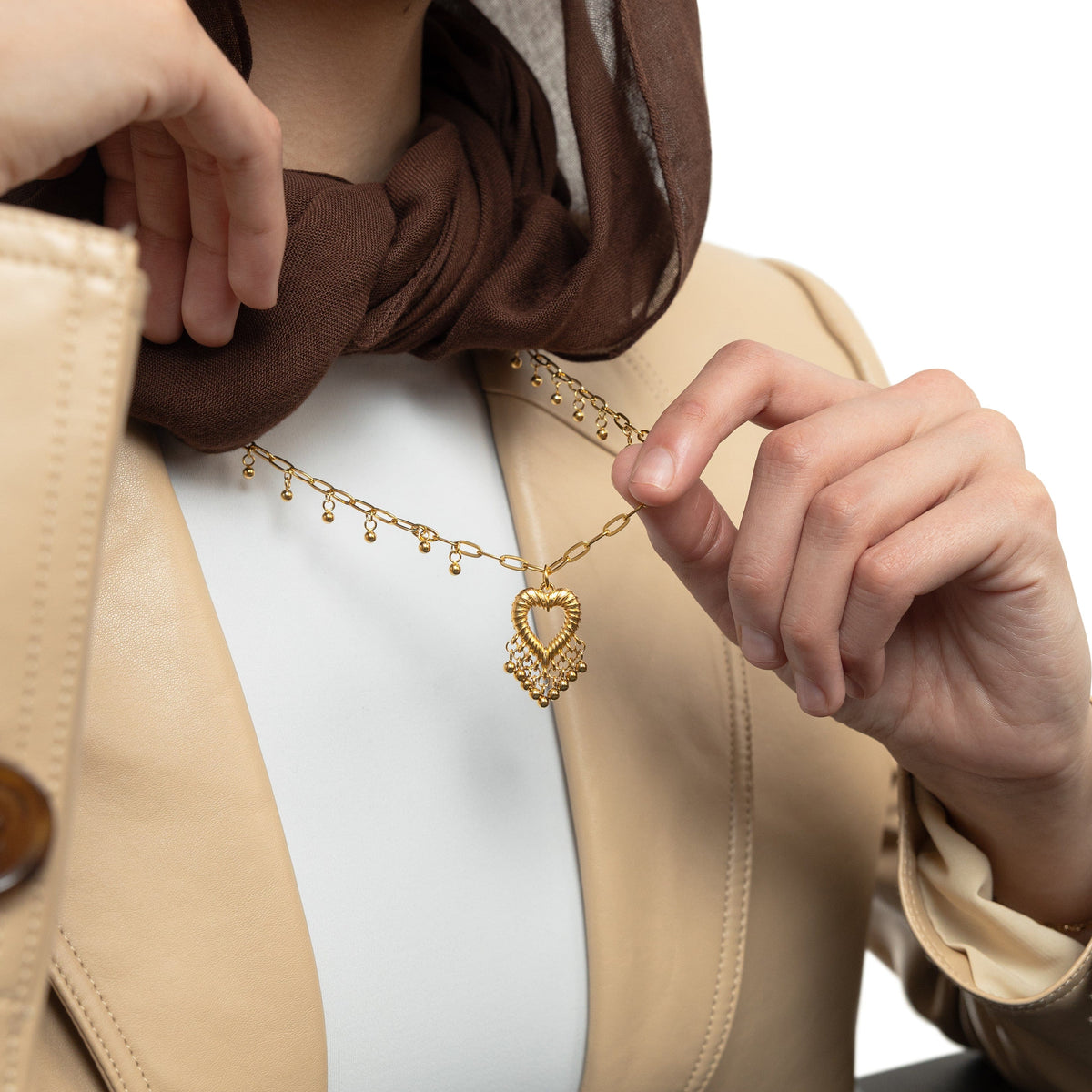 A model wearing the gold-plated Dotted Heartthrob Necklace, with the pendant resting elegantly on her chest, highlighting the intricate design.
