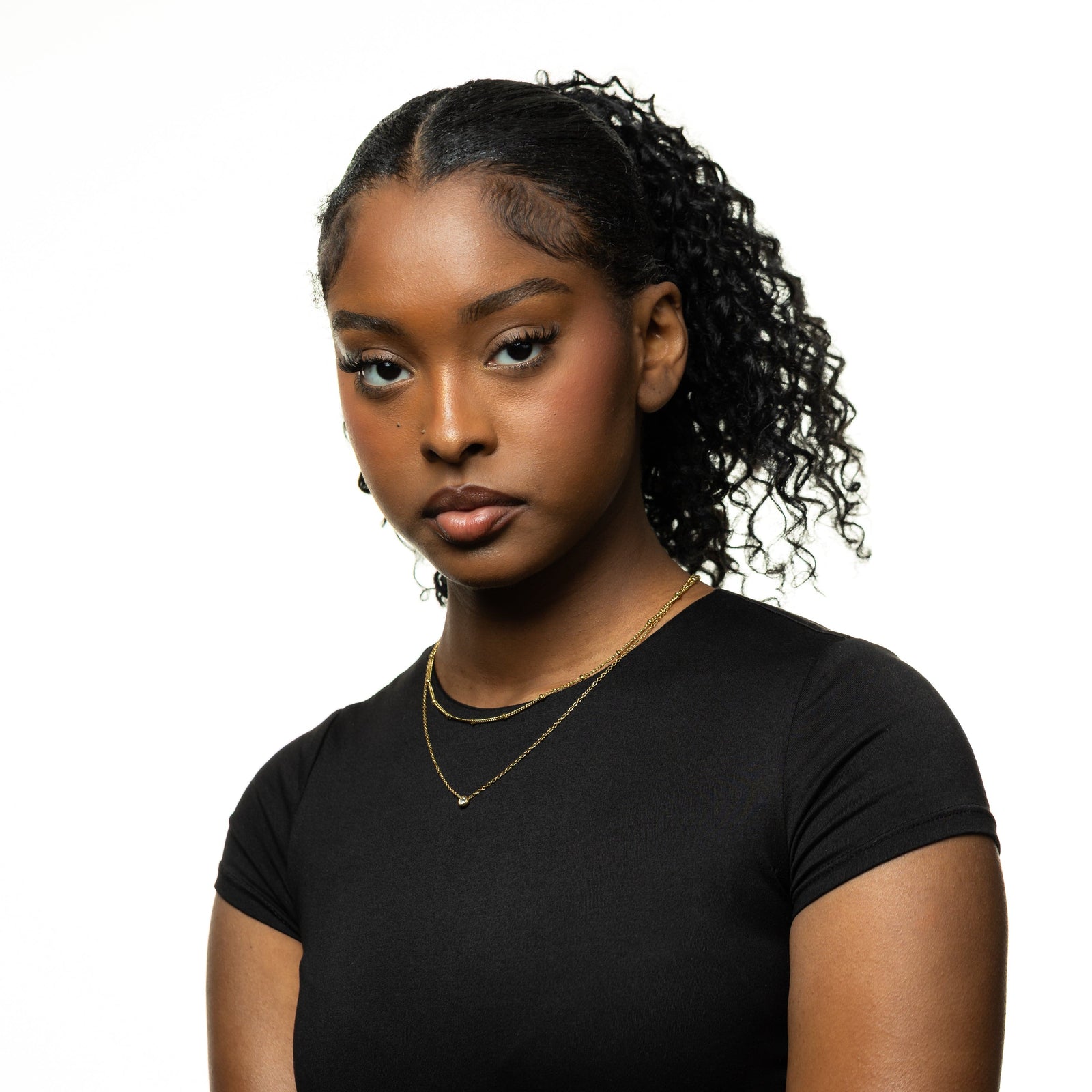 Photo of the model looking at the camera. The model is wearing the gold Dotted & Bezel Layering Set.