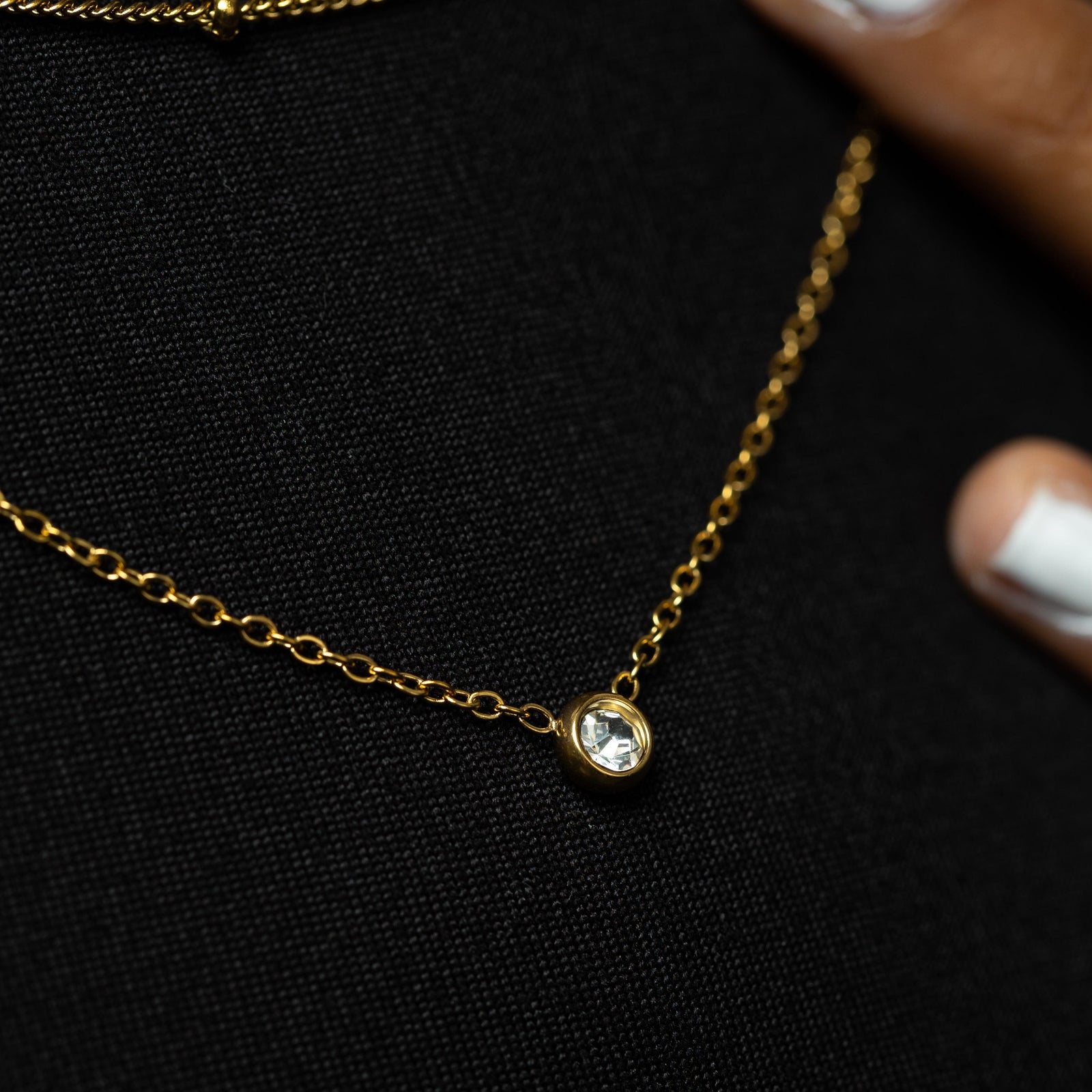 Close up of the gold Dotted & Bezel Layering Set as worn by the model.