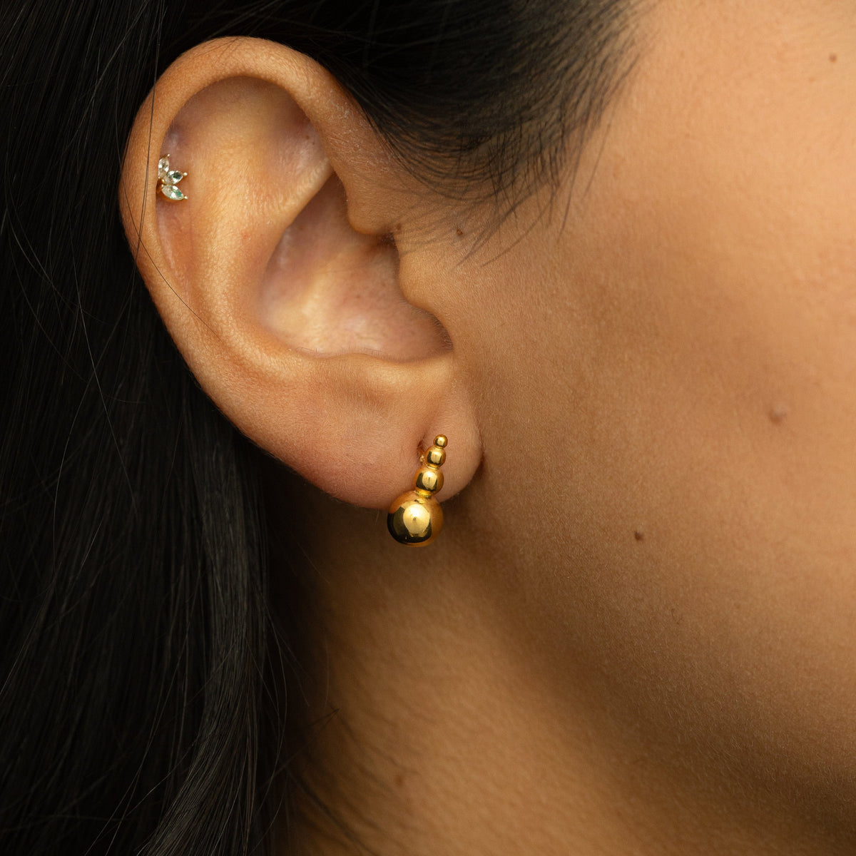 Gold Dotted Studs styled on ear with a natural finish.