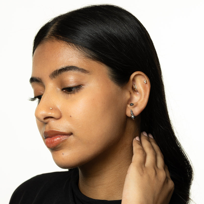 Woman wearing the silver Dotted Studs close to the ear.