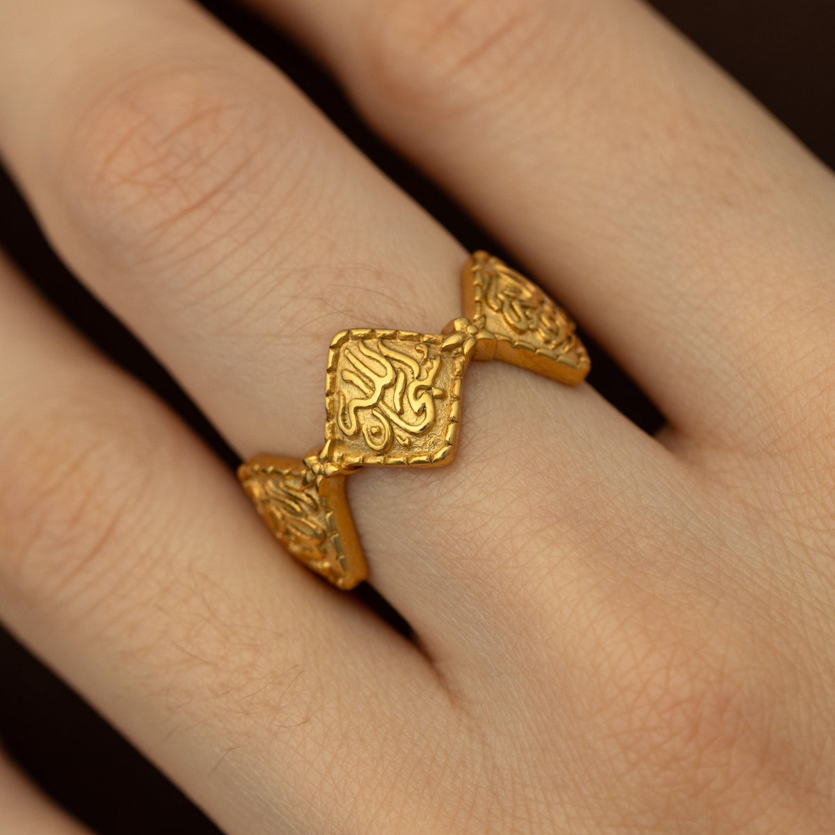 Close up photo of the gold Dotted Thikr Ring as worn by a model.