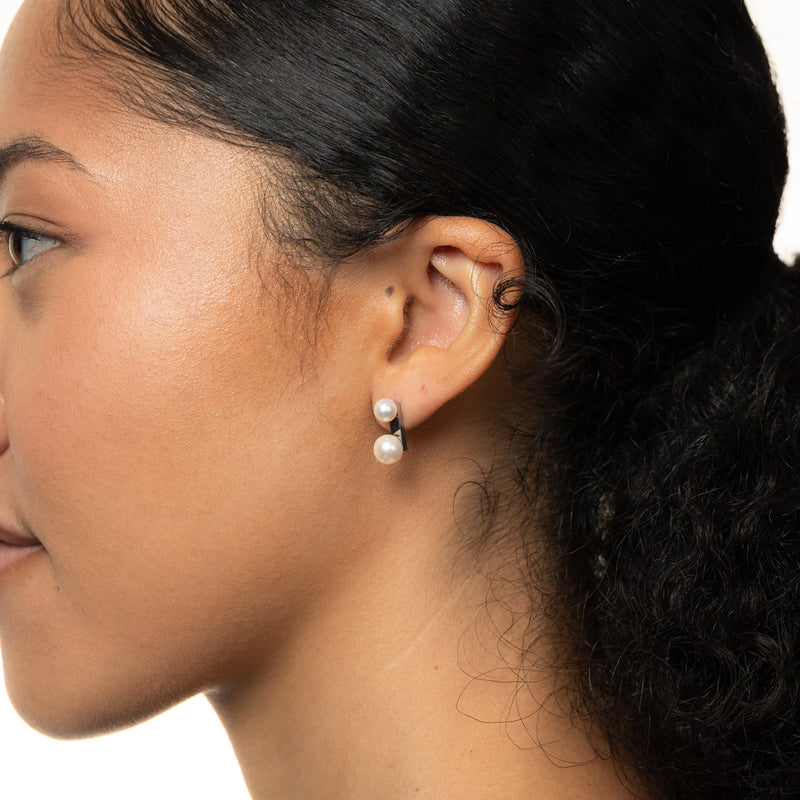 Close-up of a woman wearing silver duo pearl stud