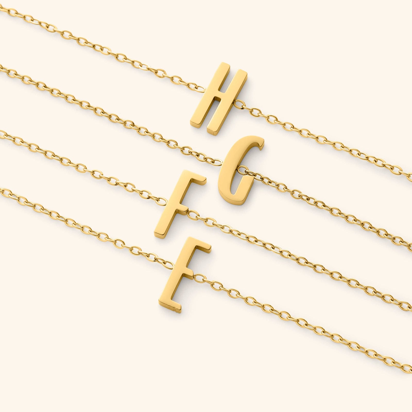 Gold bracelets with english letter pendants on a white background
