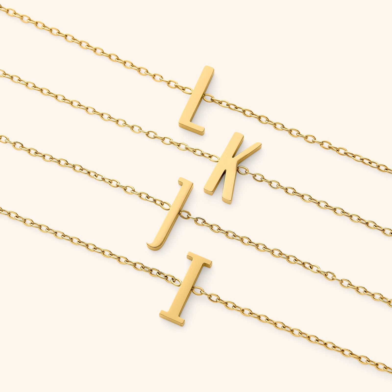 Gold bracelets with english letter pendants on a white background