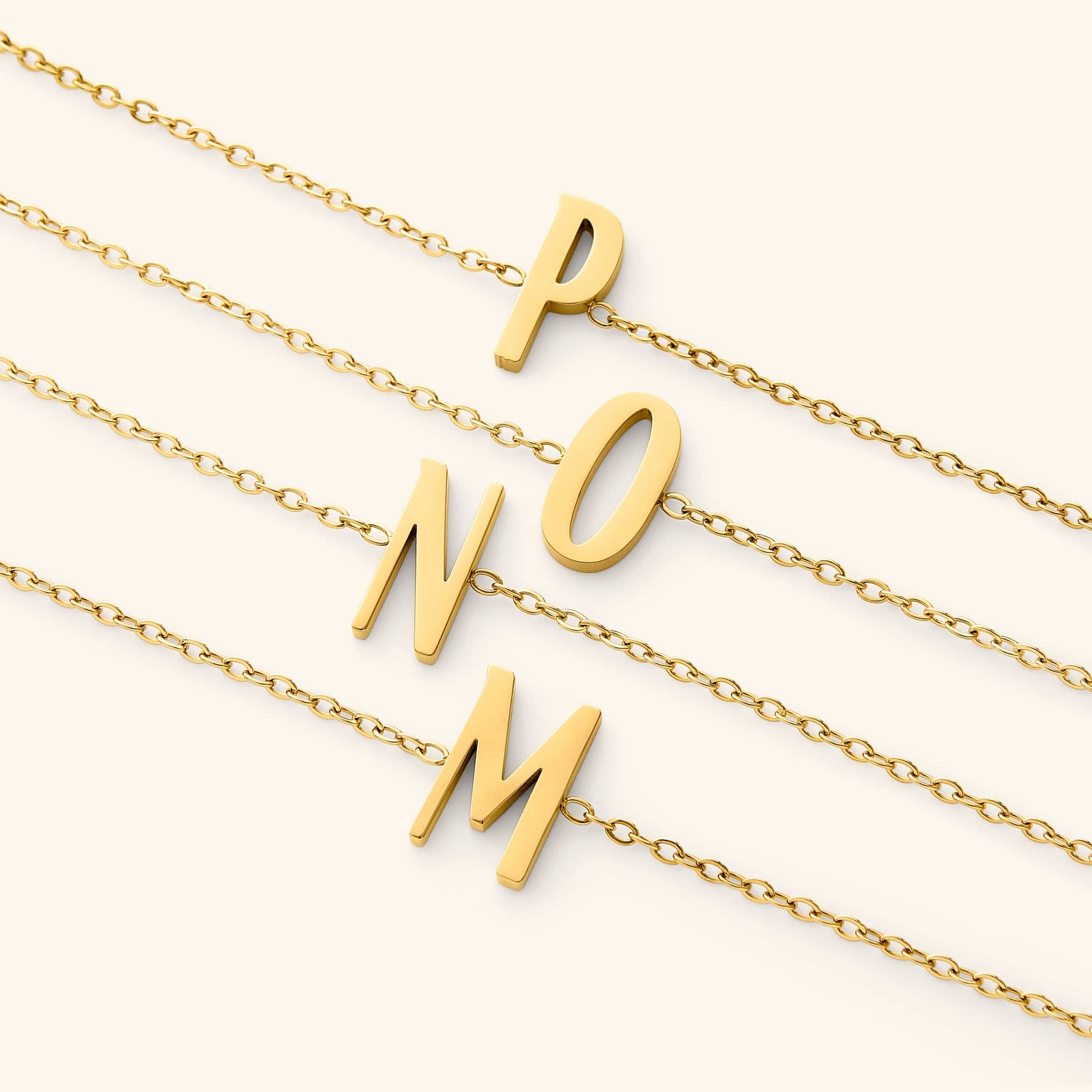 Gold bracelets with english letter pendants on a white background
