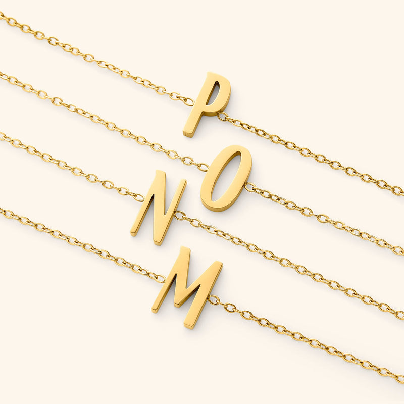 Gold bracelets with english letter pendants on a white background