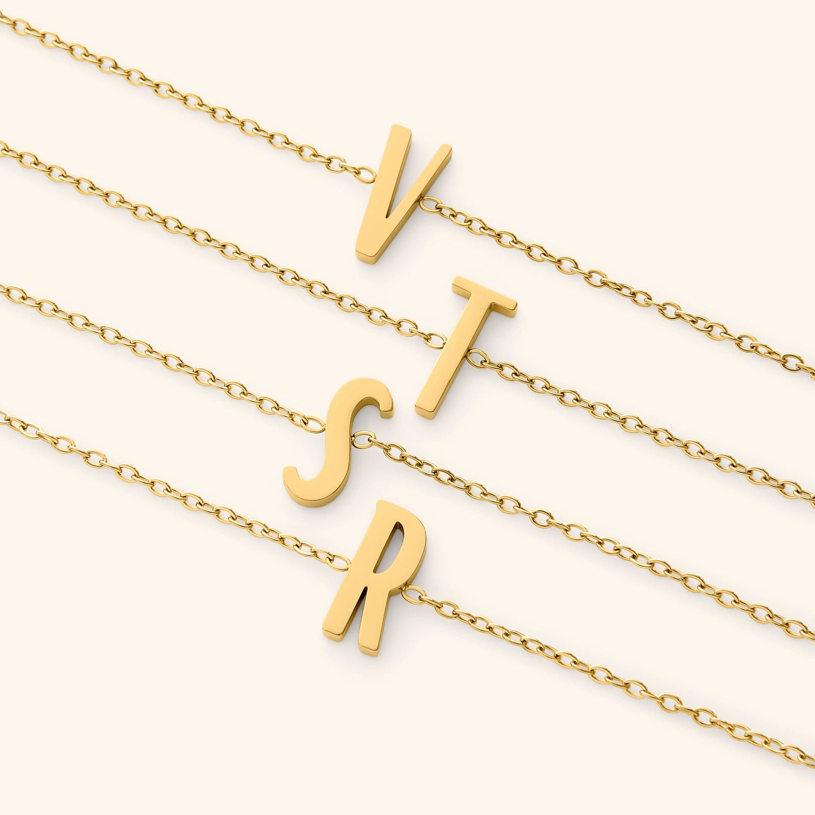 Gold bracelets with english letter pendants on a white background