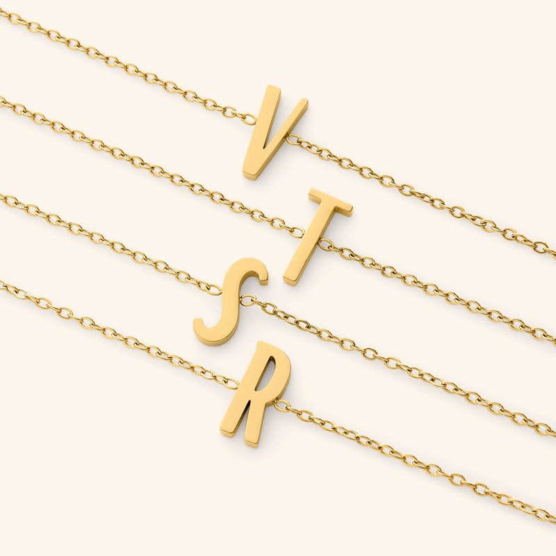Gold bracelets with english letter pendants on a white background