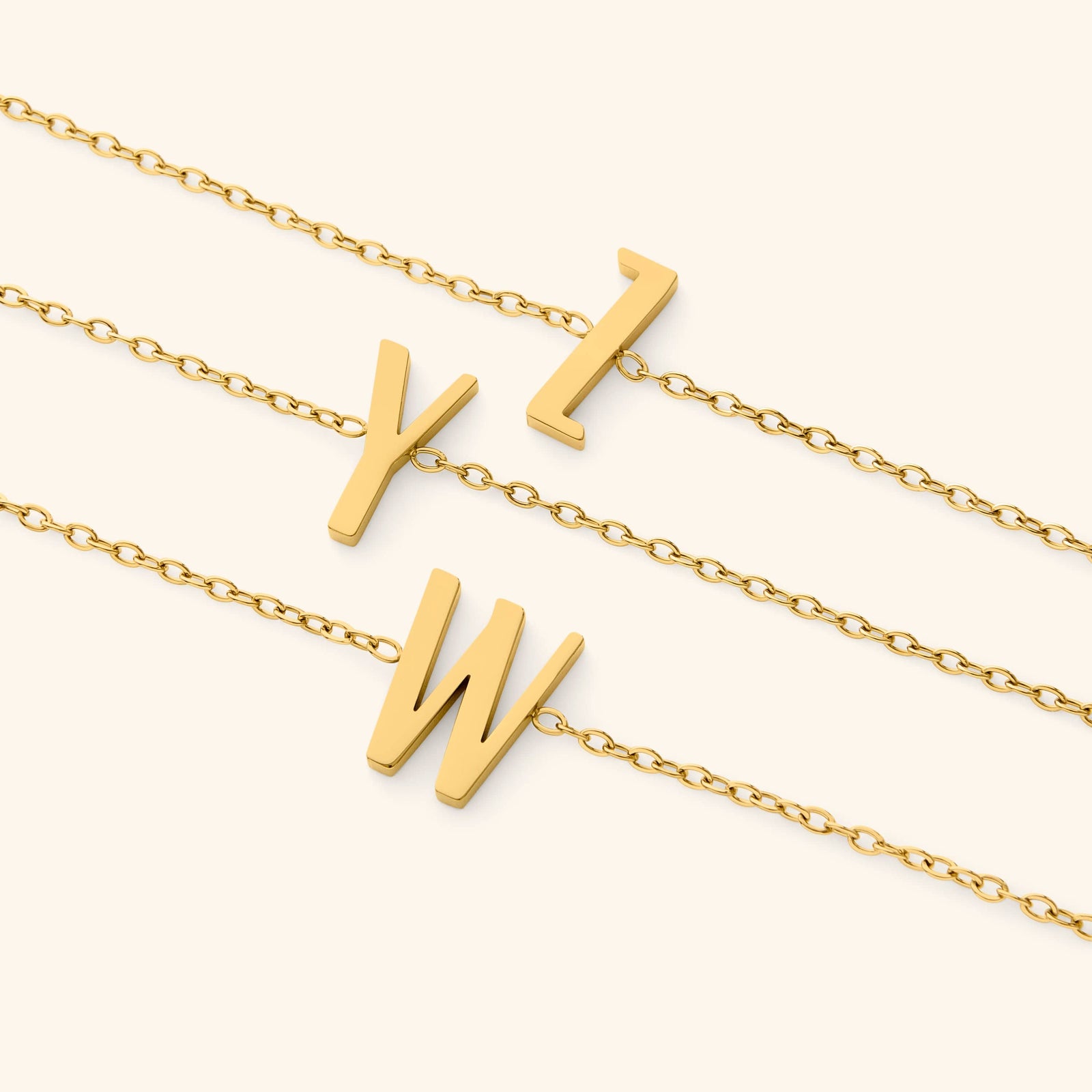 Gold bracelets with english letter pendants on a white background