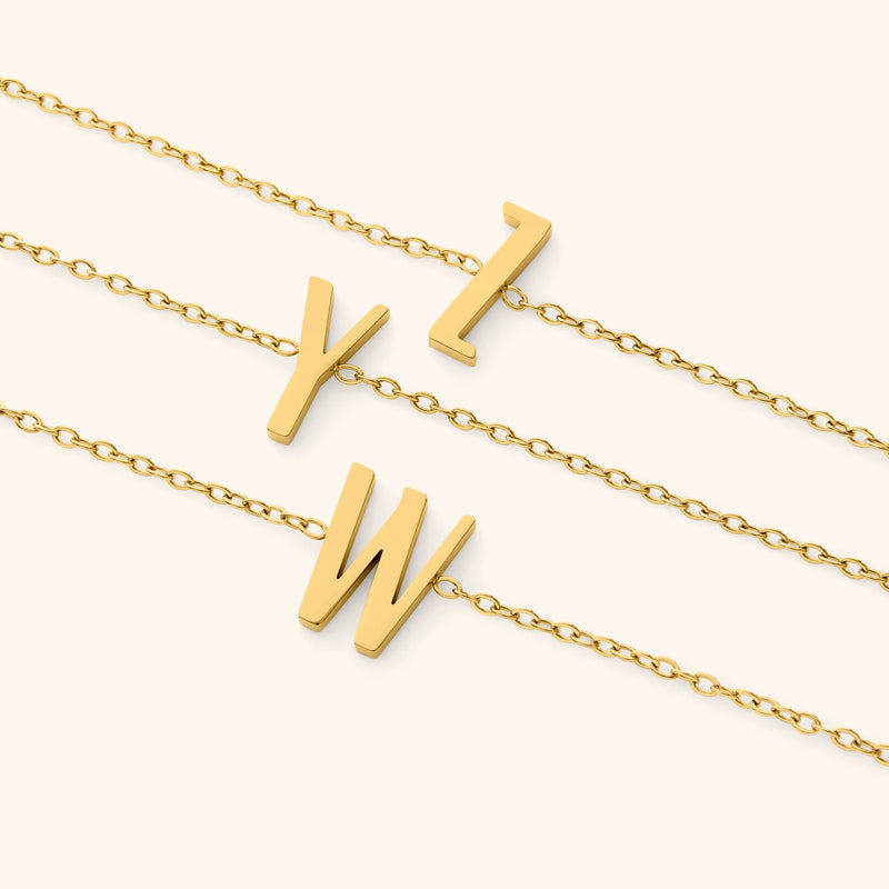 Gold bracelets with english letter pendants on a white background