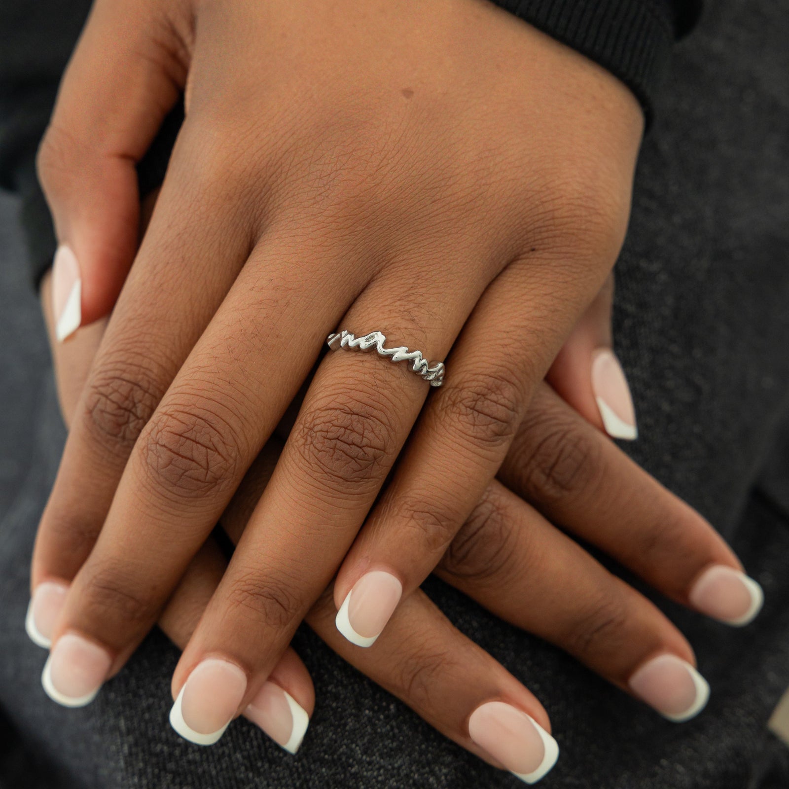 A model showcasing the silver English Mama Ring on her finger. 