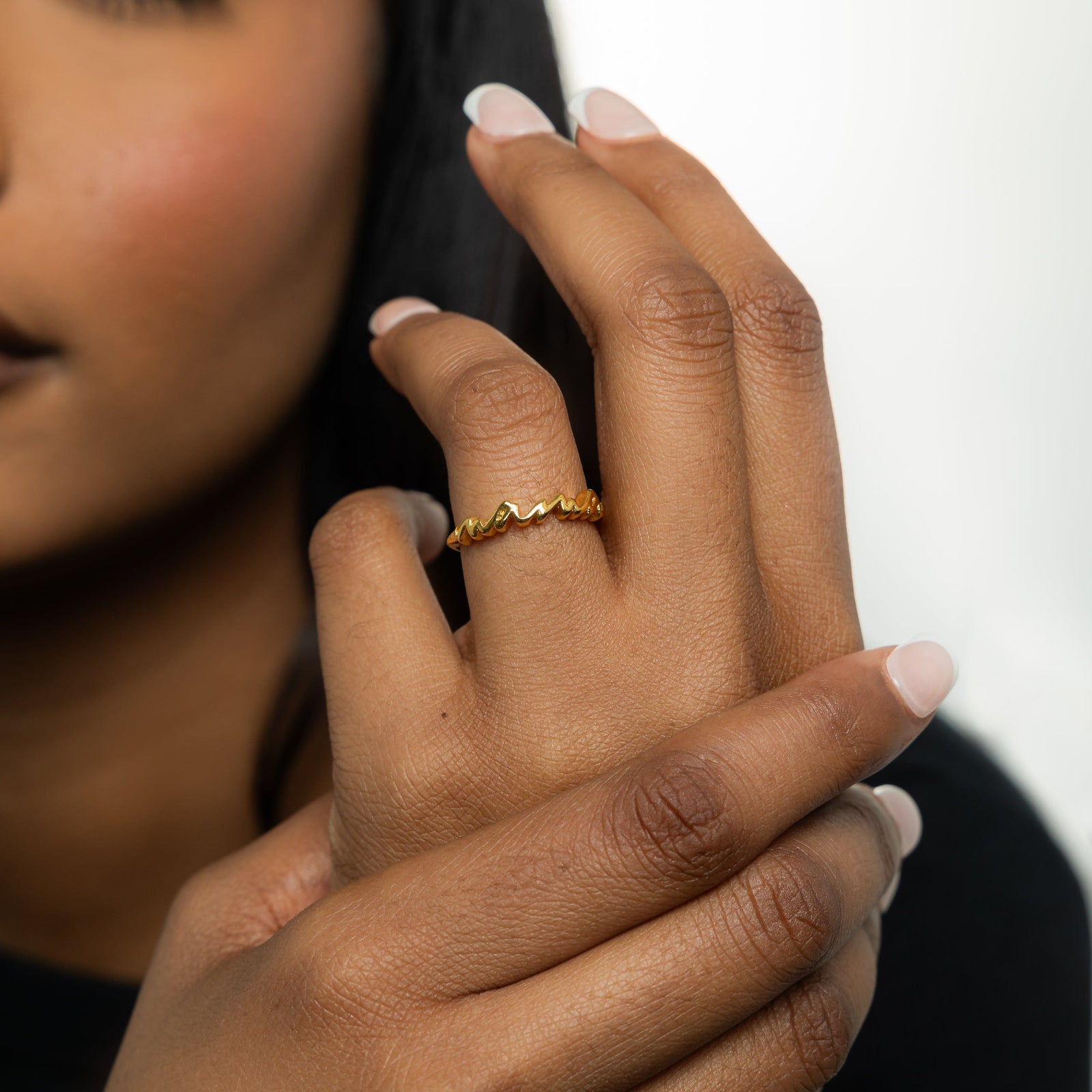 A model wearing the 18K gold-plated English Mama Ring on her finger. T