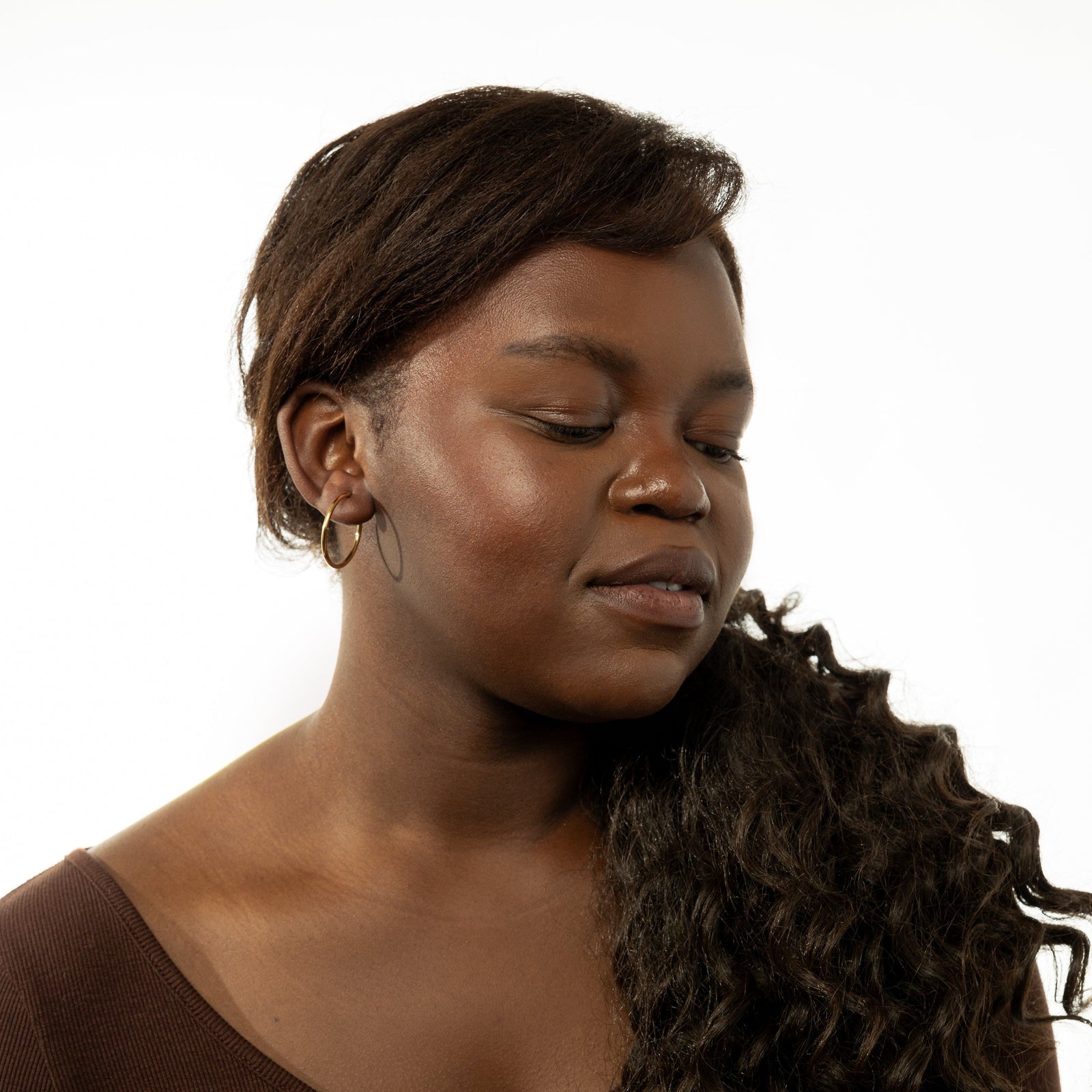 Photo of the model wearing the Essential Open Hoops | 26mm on their right ear.