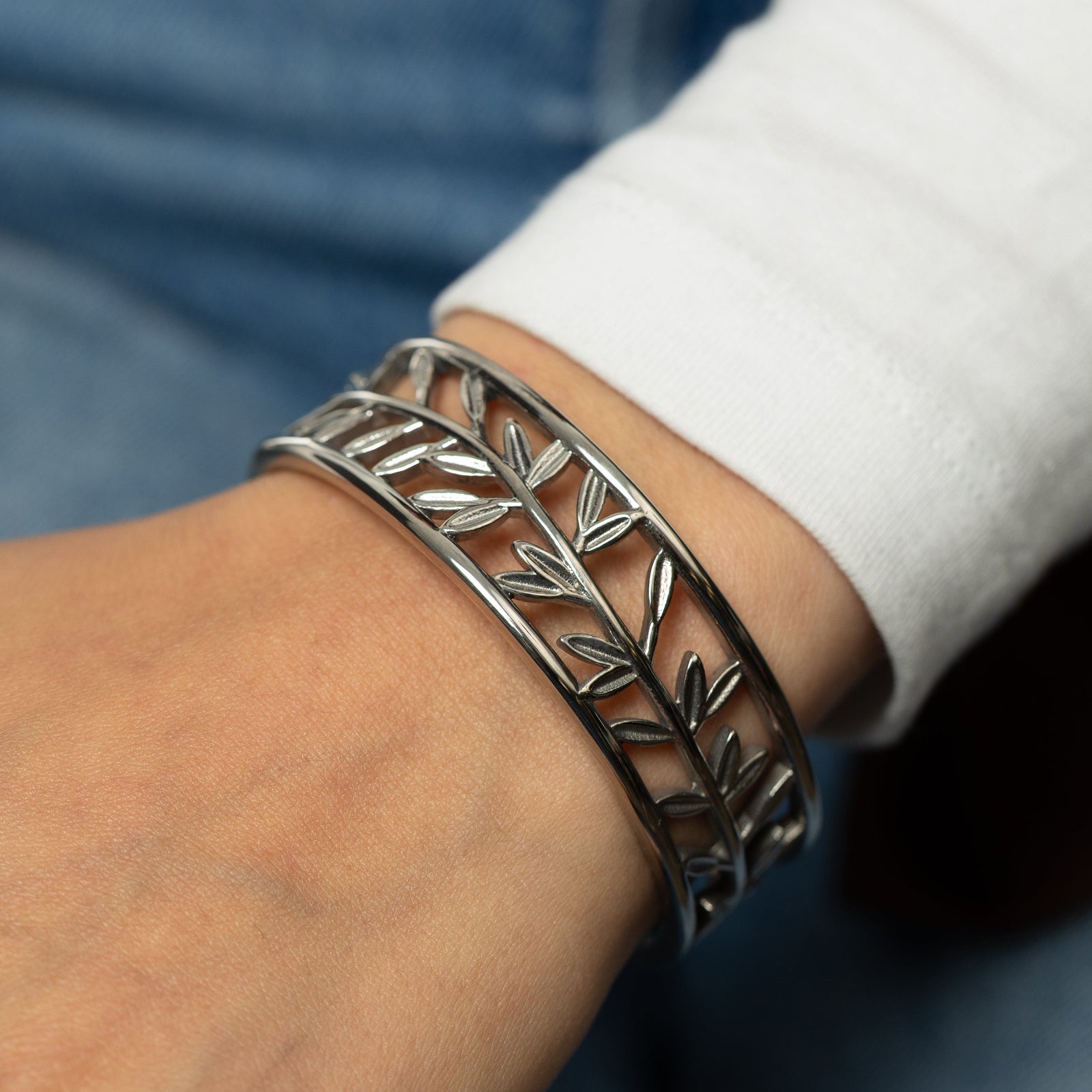 Silver Eternal bangle with olive leaves pattern worn on wrist 