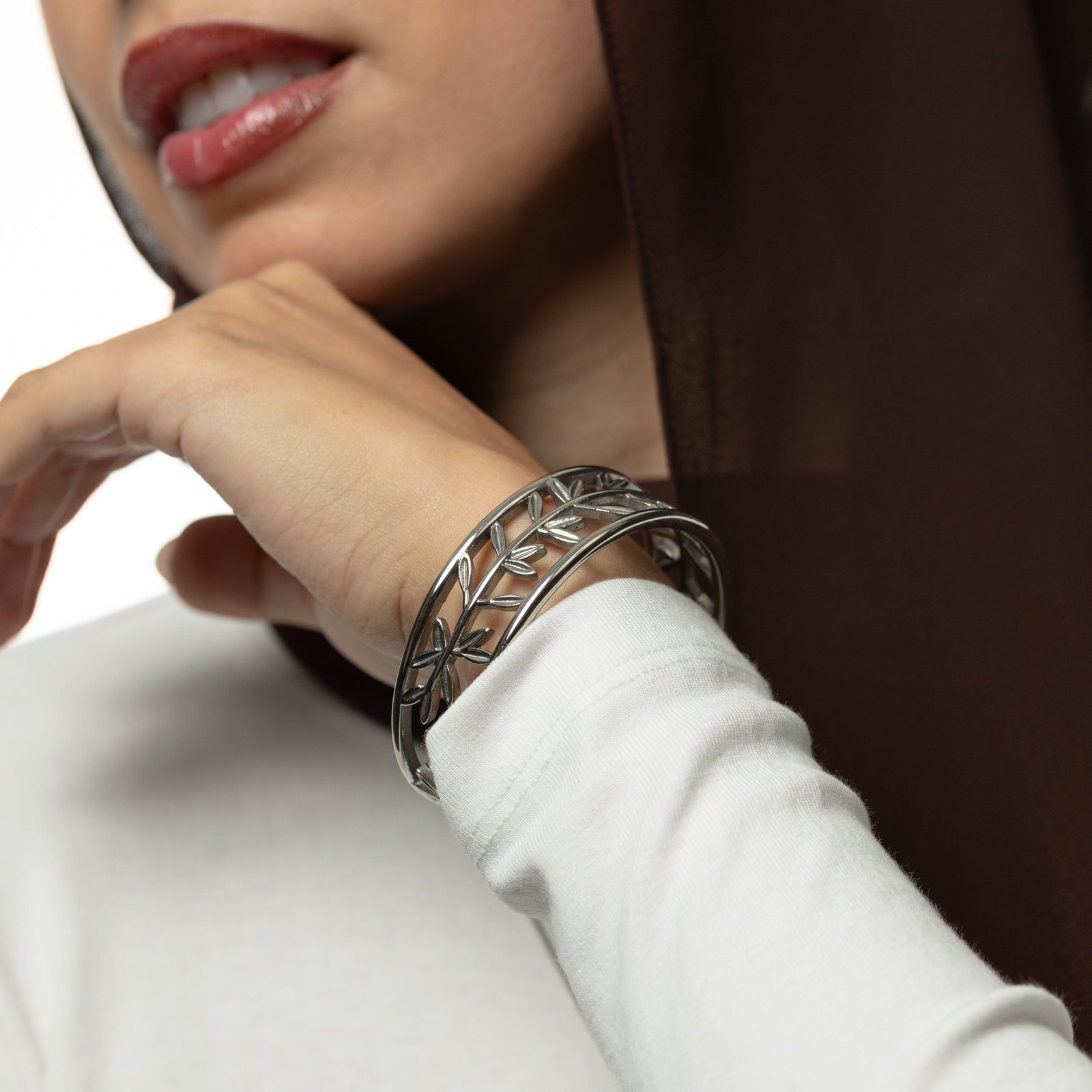 Close-up of a person wearing a silver Eternal bangle