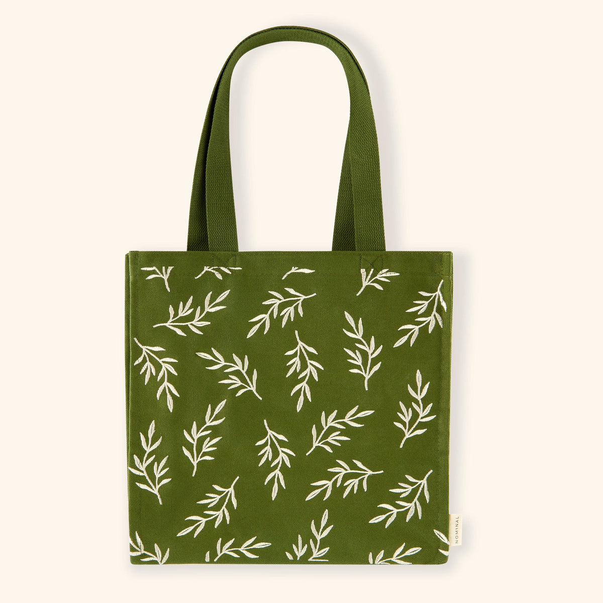 Forest green tote bag with cream embroidered olive branches scattered across the surface.