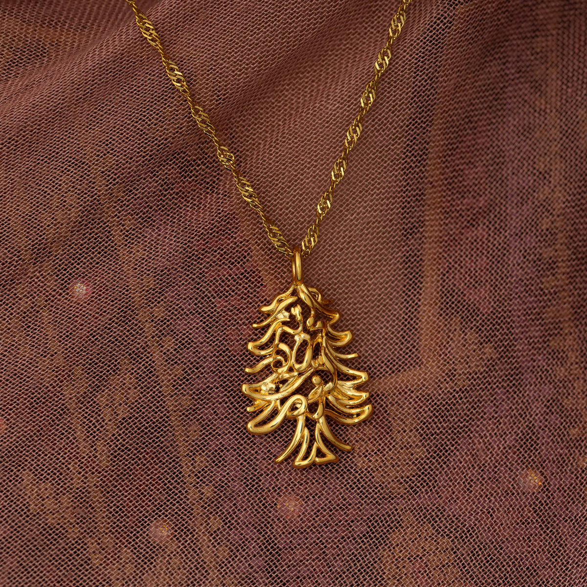 Close up photo of the necklace focusing on the pendant as it rests on a fabric.