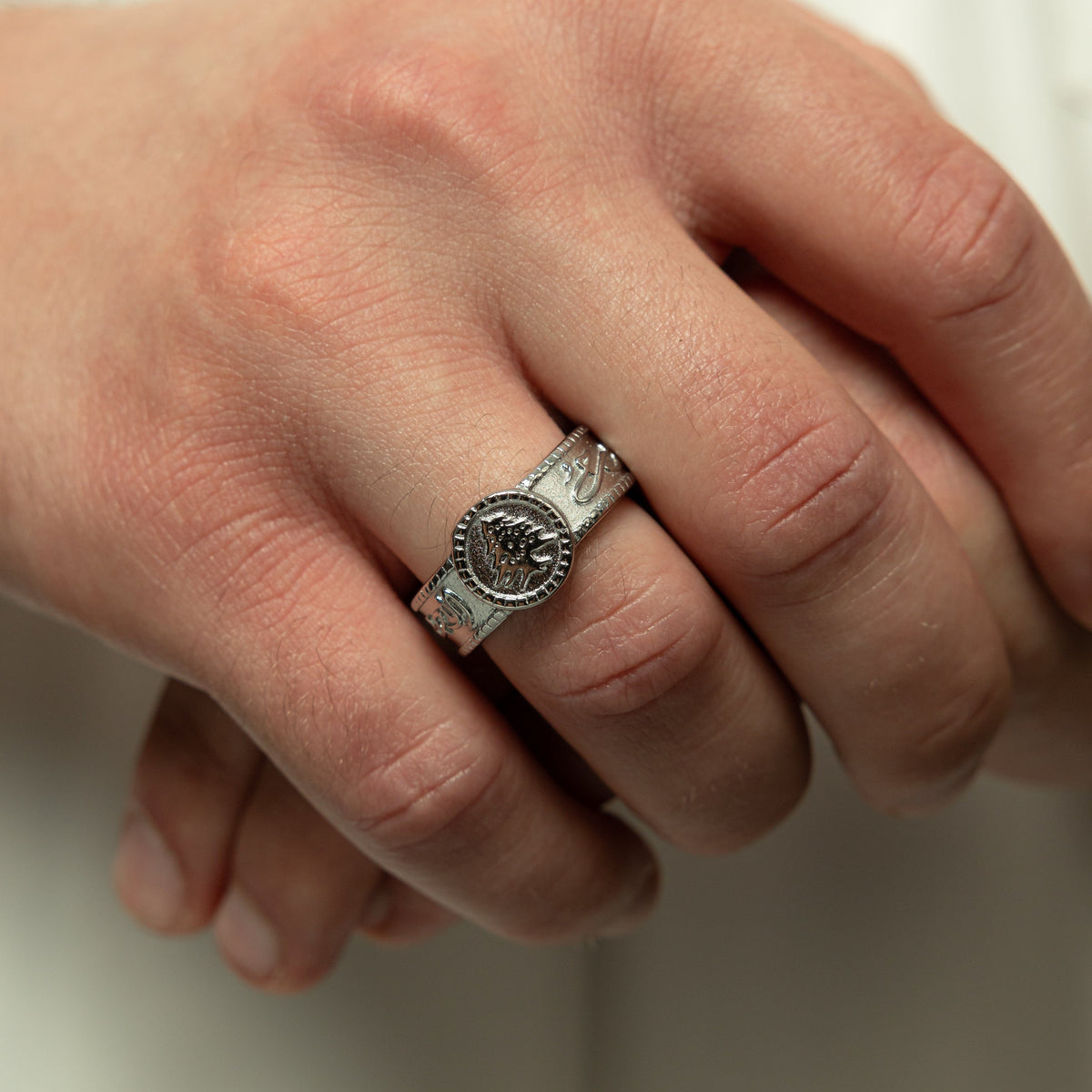 Close up of the model's right hand holding their left hand wearing the silver Freedom is the soul Ring | Men on their left ring finger.