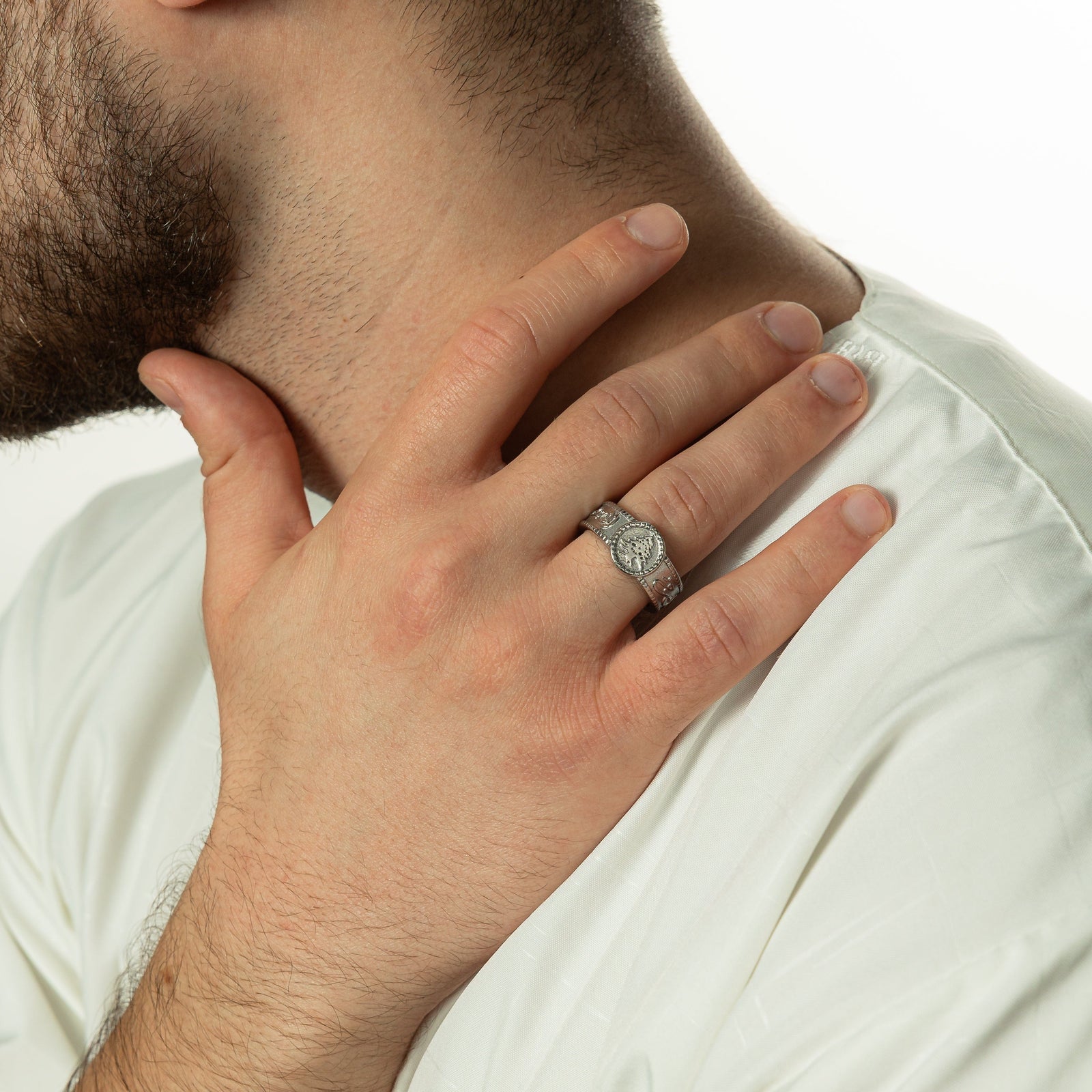 Photo of the model's right hand on their neck just above the right shoulder. Model is wearing the silver Freedom is the Soul Ring on their right ring finger.