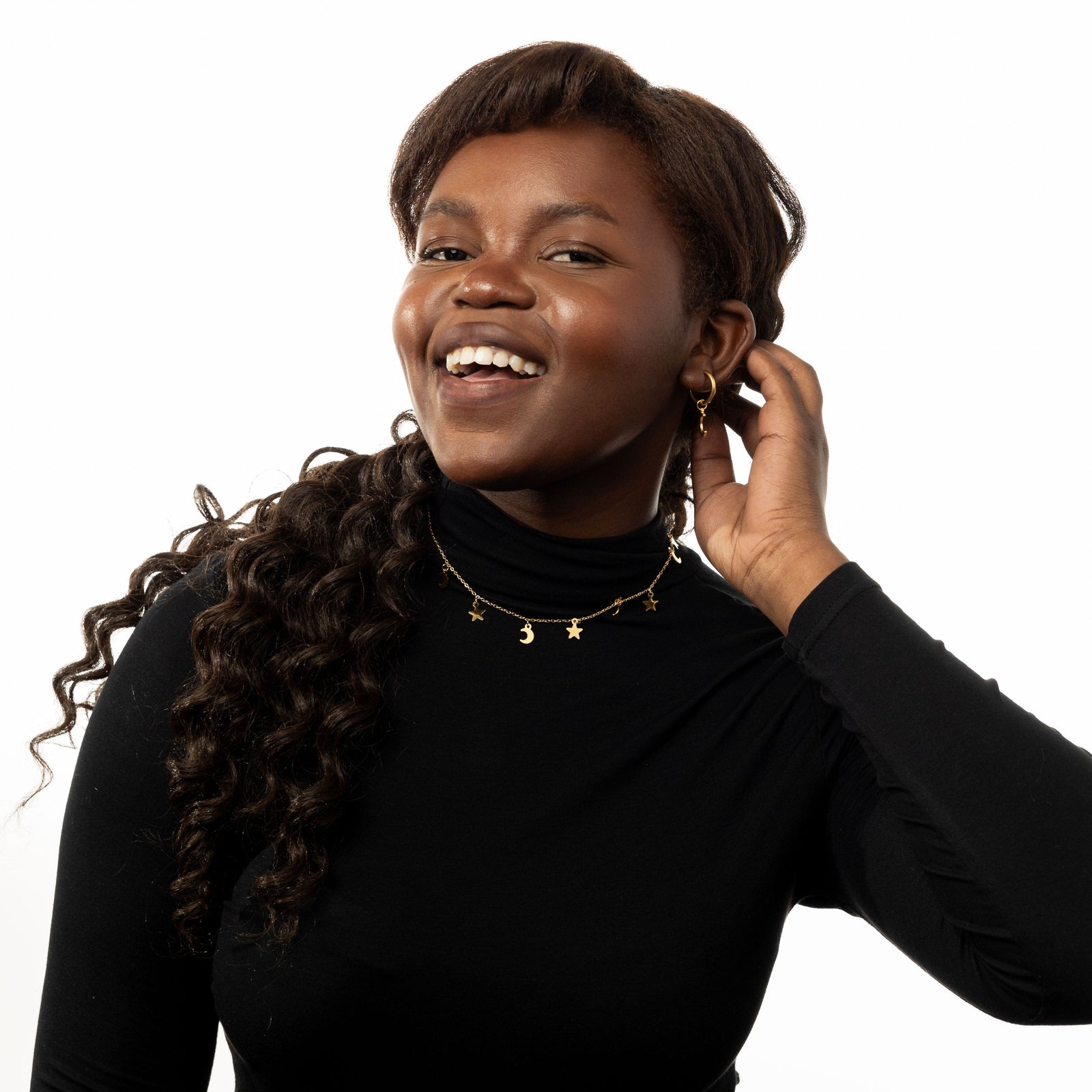 Photo of the model smiling to the camera. The model is wearing the Galaxy Hoop Earrings and gold necklace.
