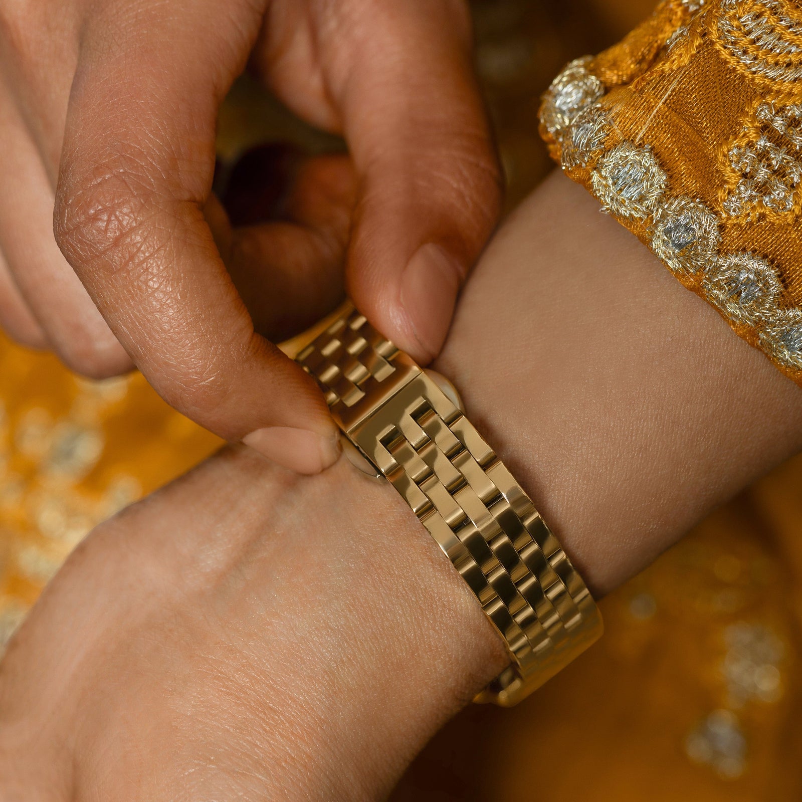 Model holding on the the lock of the watch.