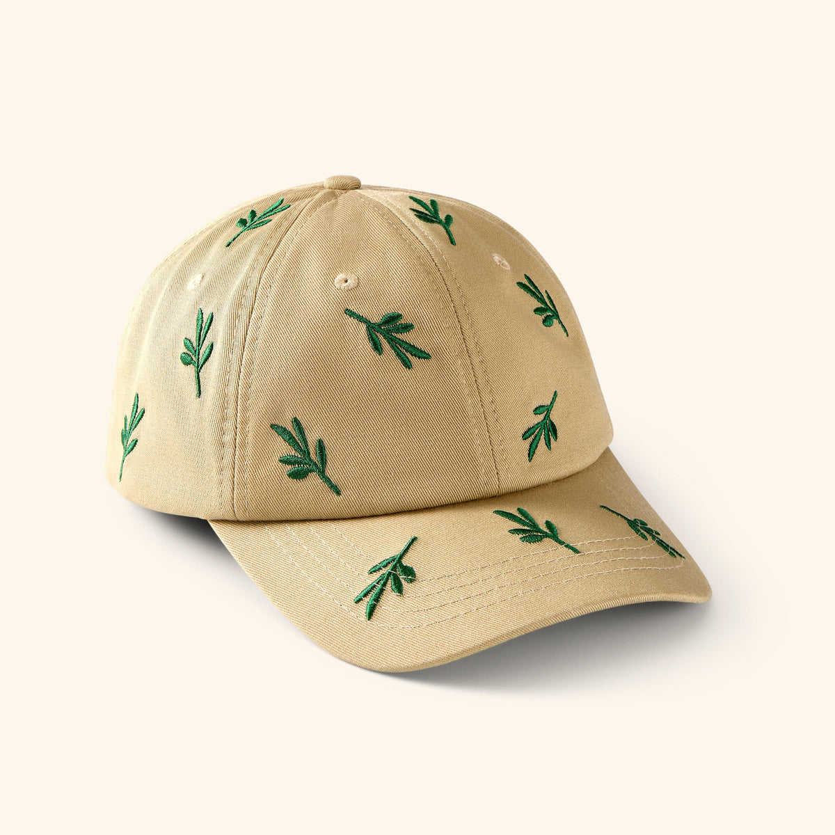 Beige baseball cap with embroidered green Olive branch patterns.