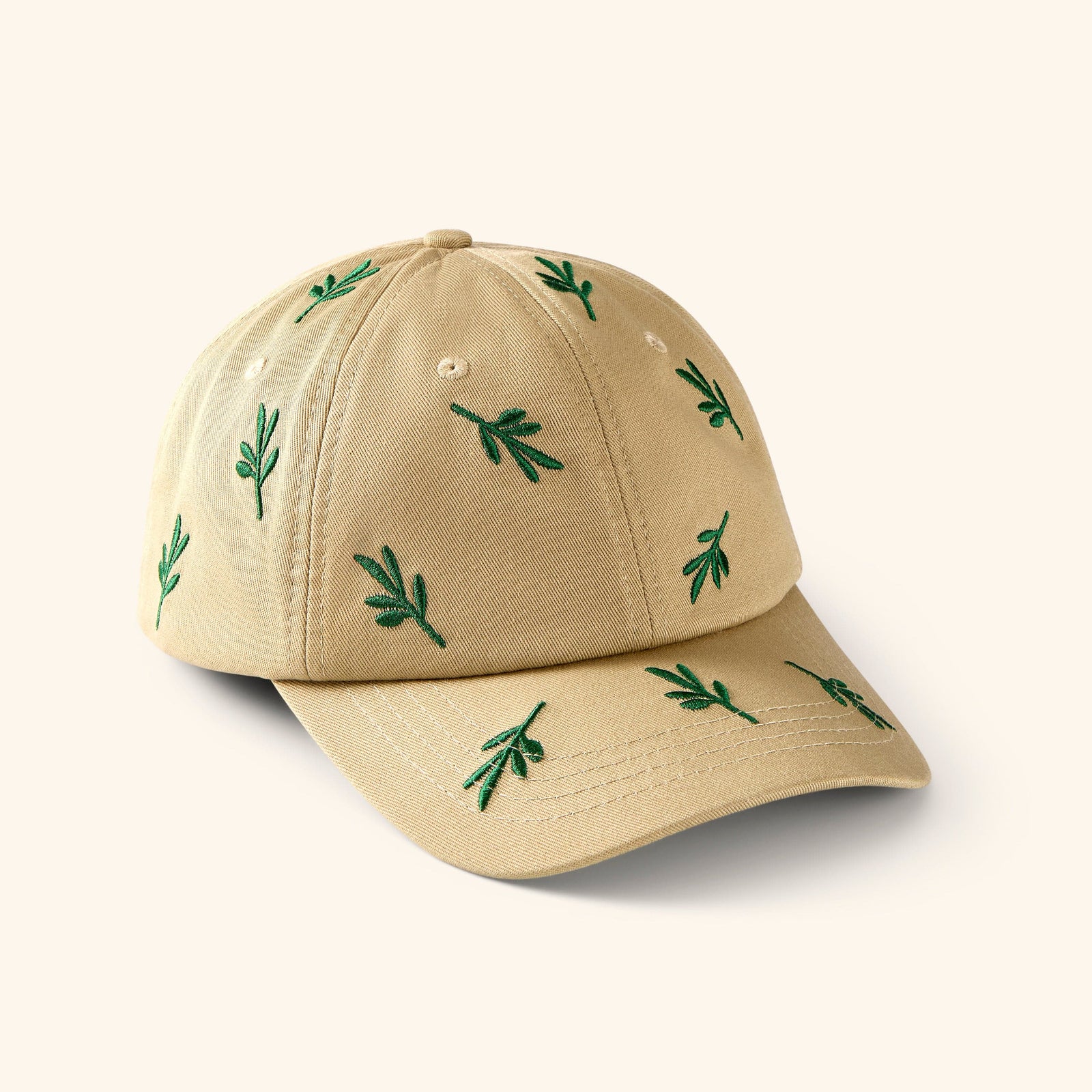 Beige baseball cap with embroidered green Olive branch patterns.
