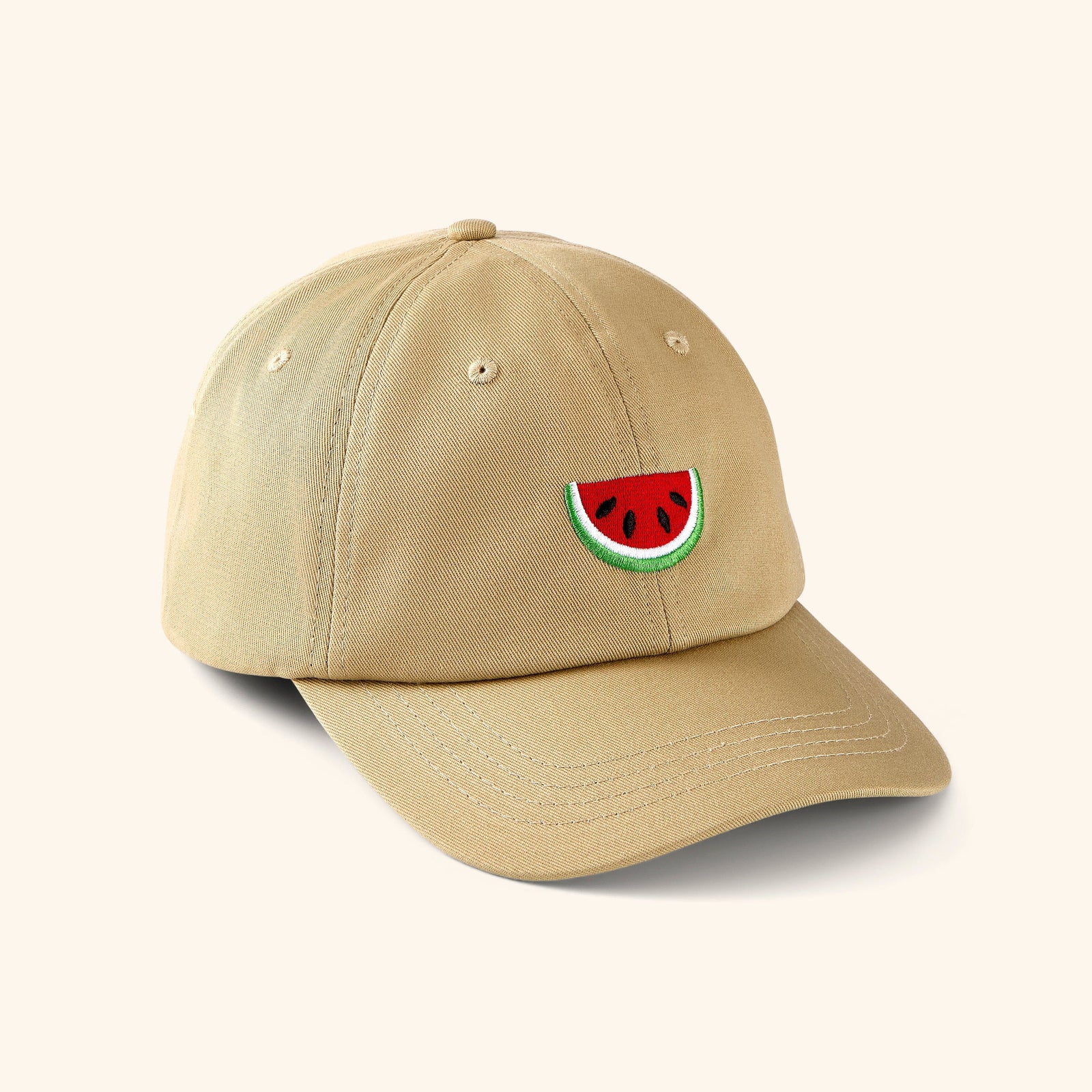 Beige baseball cap with watermelon art featuring the Red, Black, White, and Green colors embroidered in the front center.