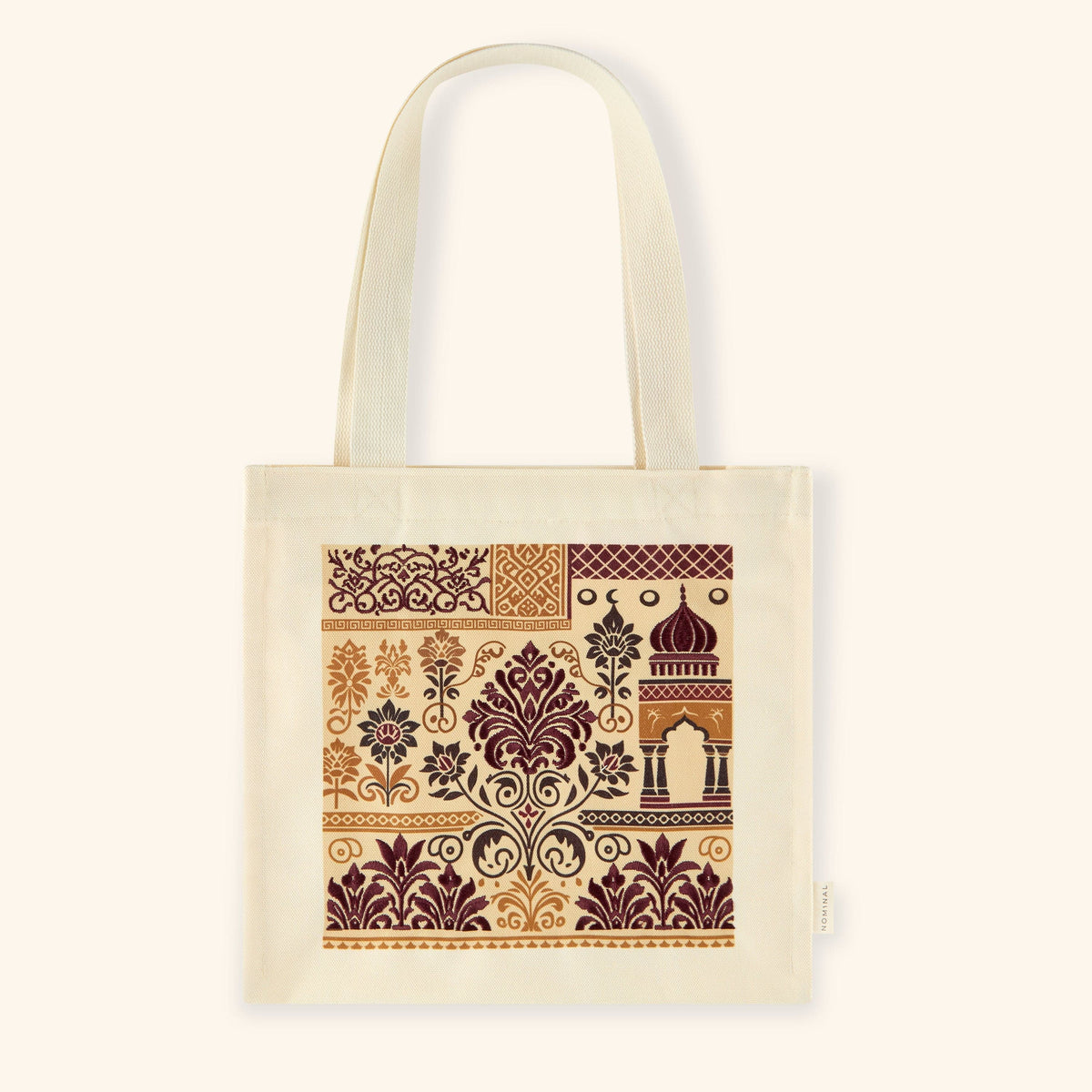 Flat lay of the heritage tote bag featuring intricate maroon, gold, and charcoal patterns, including domes and arabesque designs.