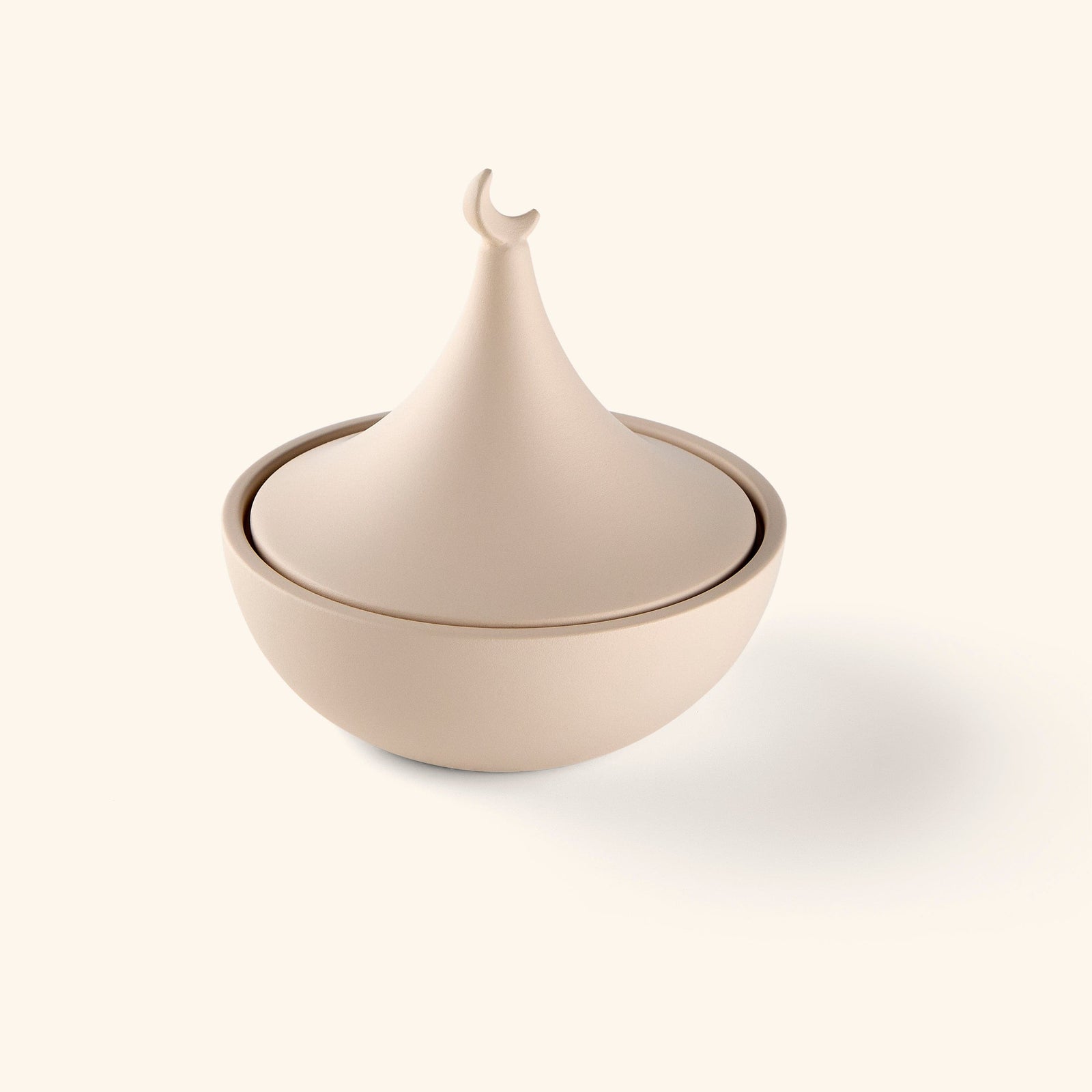 A bowl painted in beige topped with a crescent and star lid, the symbol that's appeared on flags, mosques, and textiles across the Muslim world for centuries.