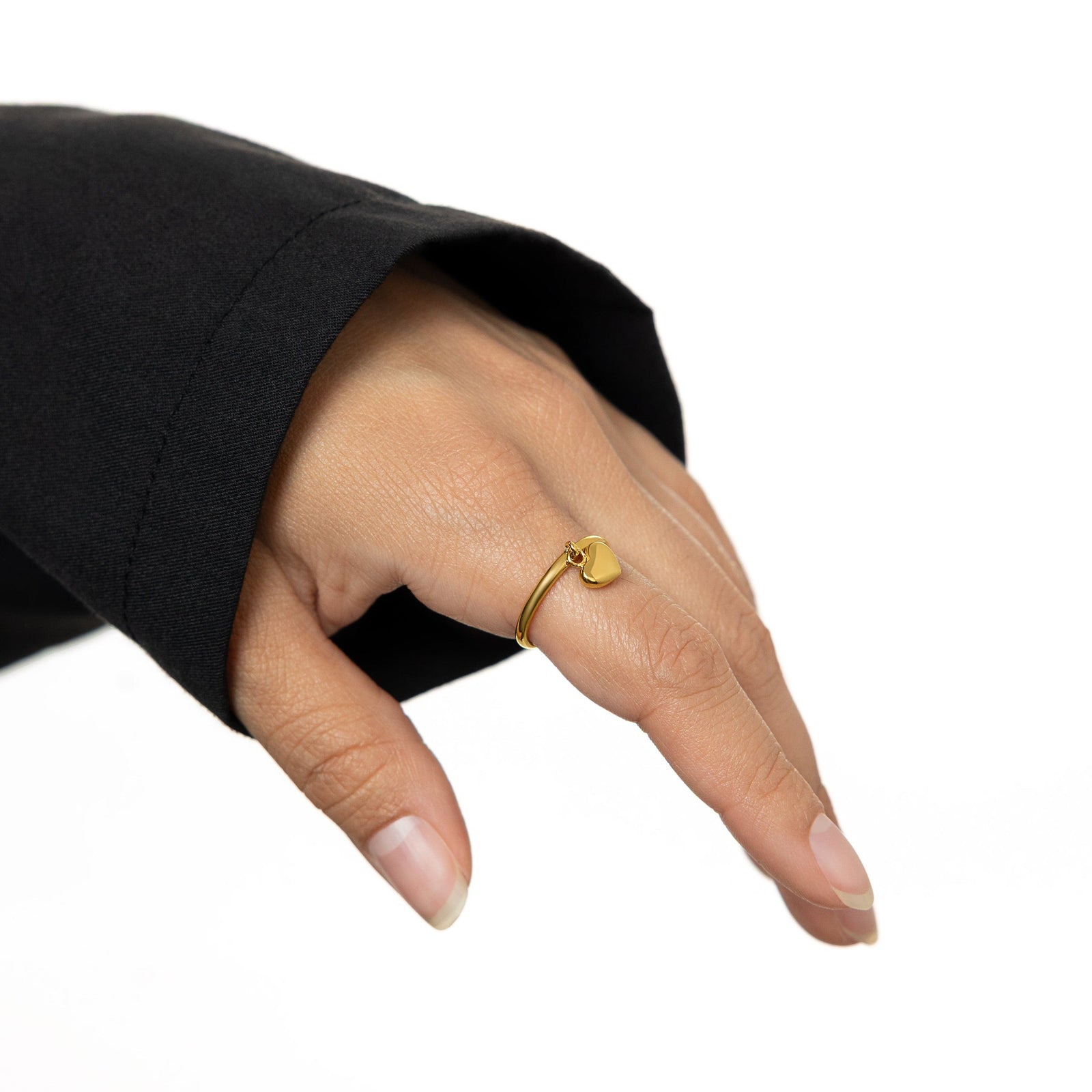 Hand shot of the gold Heart Loop Ring on the index finger.