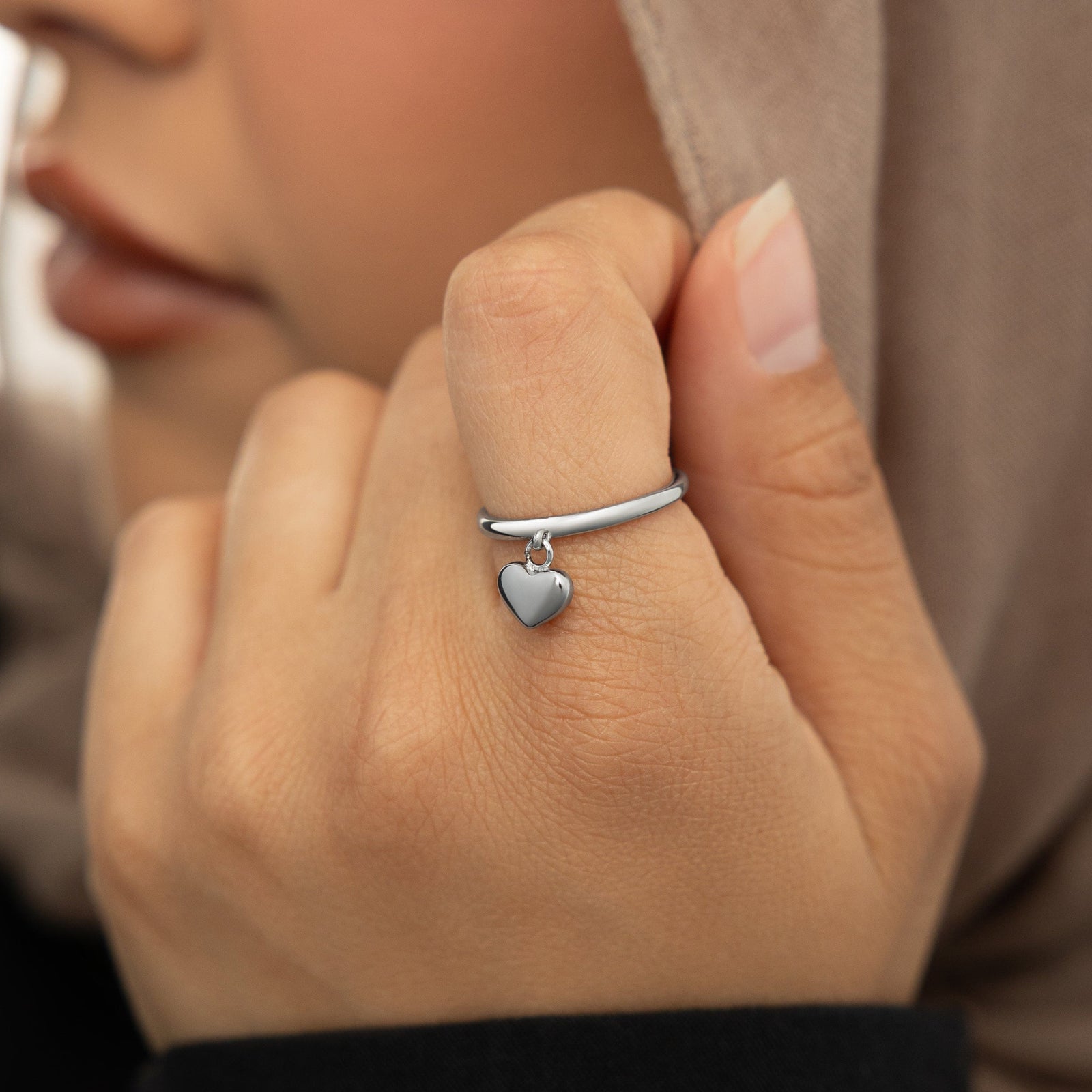 Close-up of the silver Heart Loop Ring worn on finger