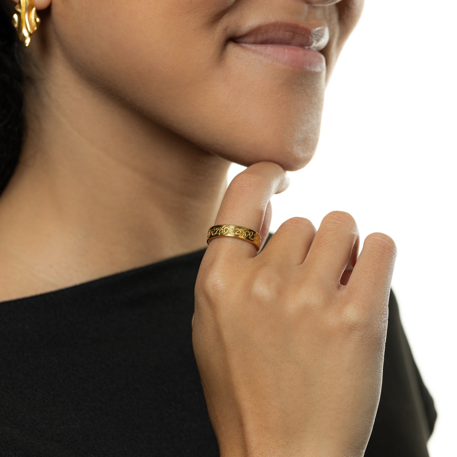 Close up of the gold “Hurriya” | Freedom Ring as worn by the model on their right index finger.