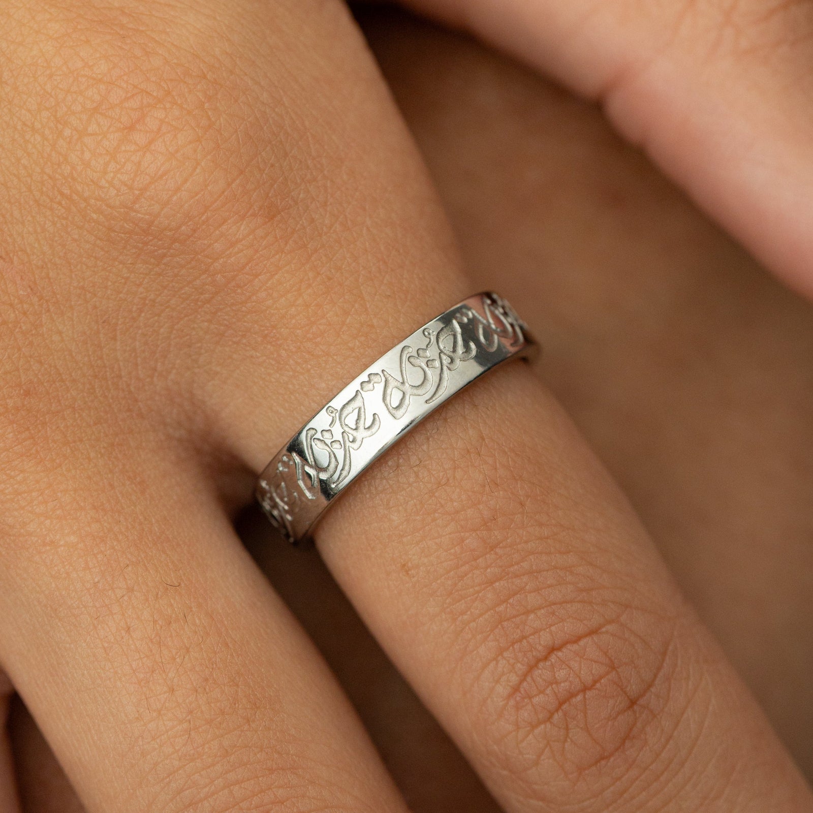 Close up of the silver “Hurriya” | Freedom Ring as worn by the model.