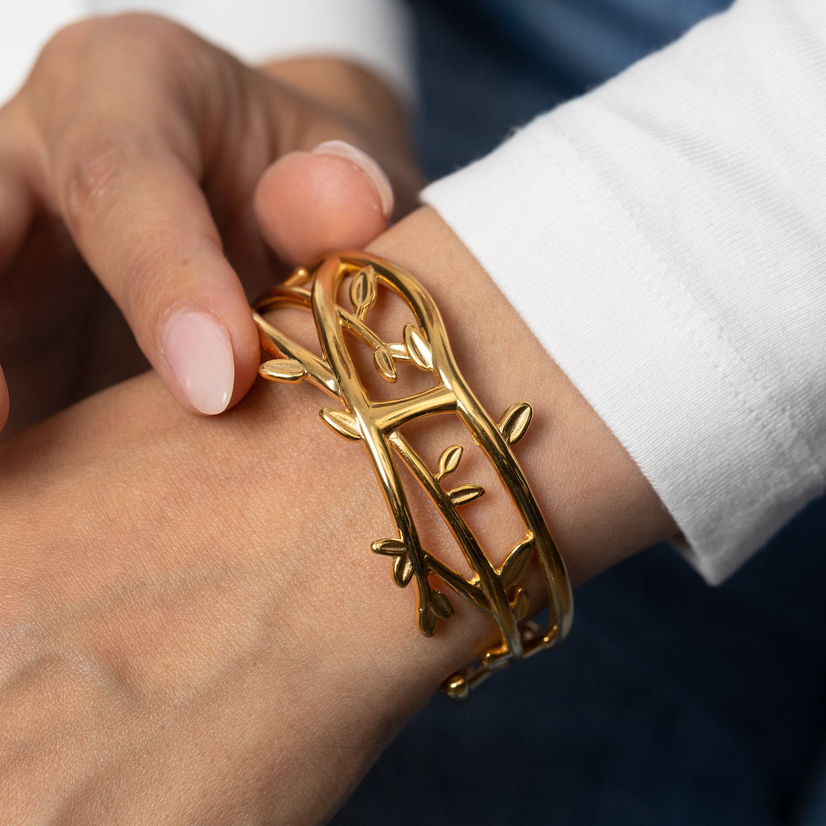 Gold Imperfect Olive Branch Cuff on a light background on a wrist.
