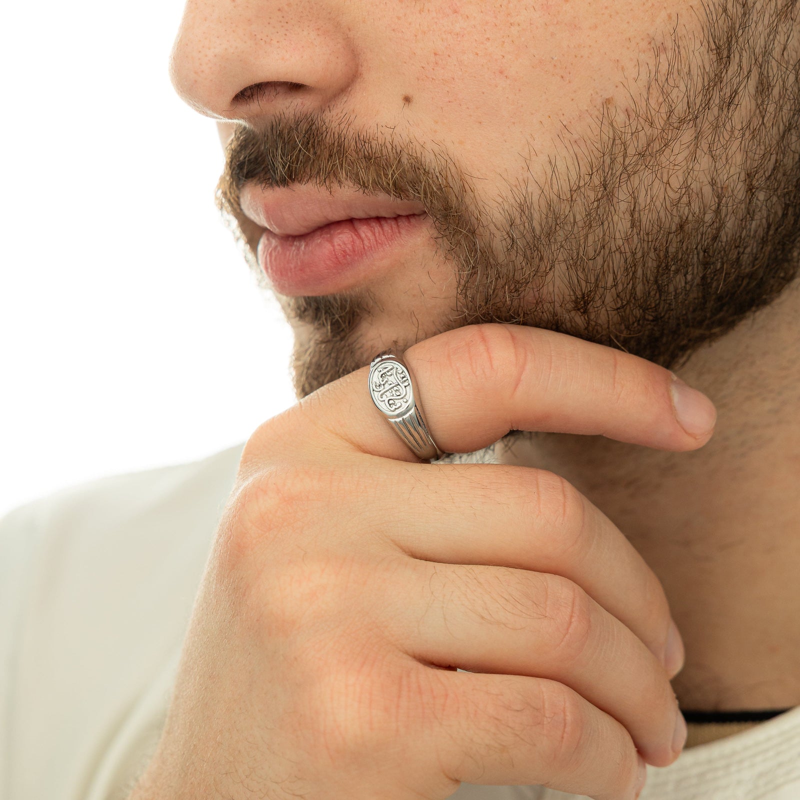 Model touches their chin with their right hand wearing the silver ring on their right index finger.