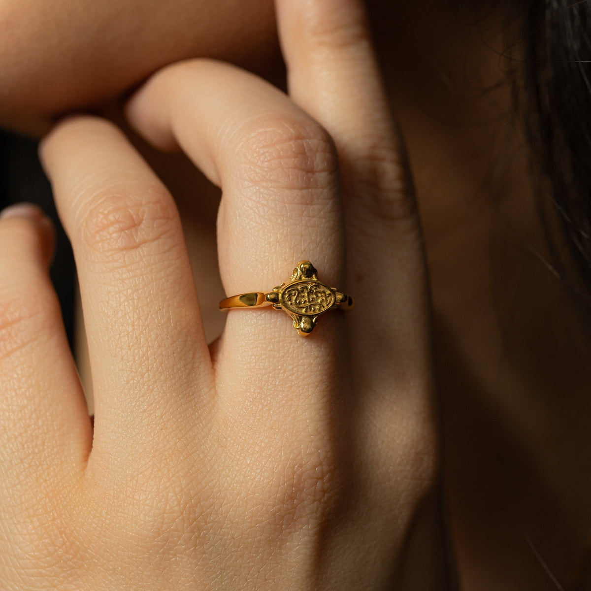 Close up of the gold In Our Hearts Vintage ring as worn by the model.