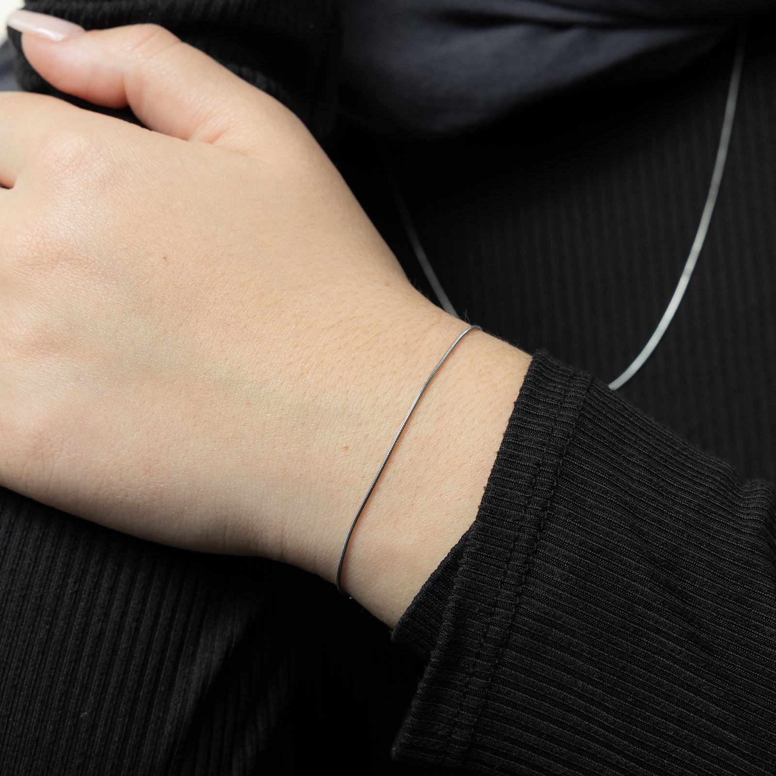Close up of the silver Micro Harmony Bracelet as worn by the model on their left wrist