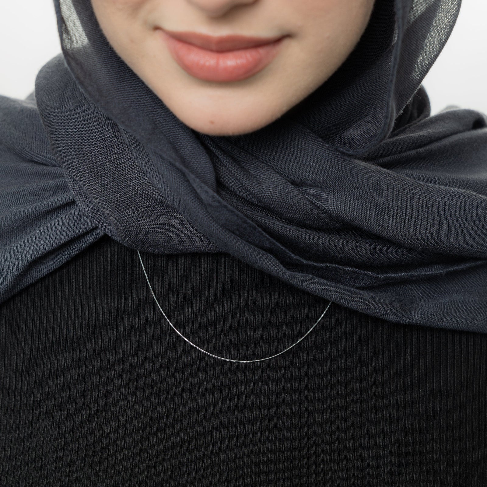 Close up of the silver Micro Harmony Chain as worn by the model.