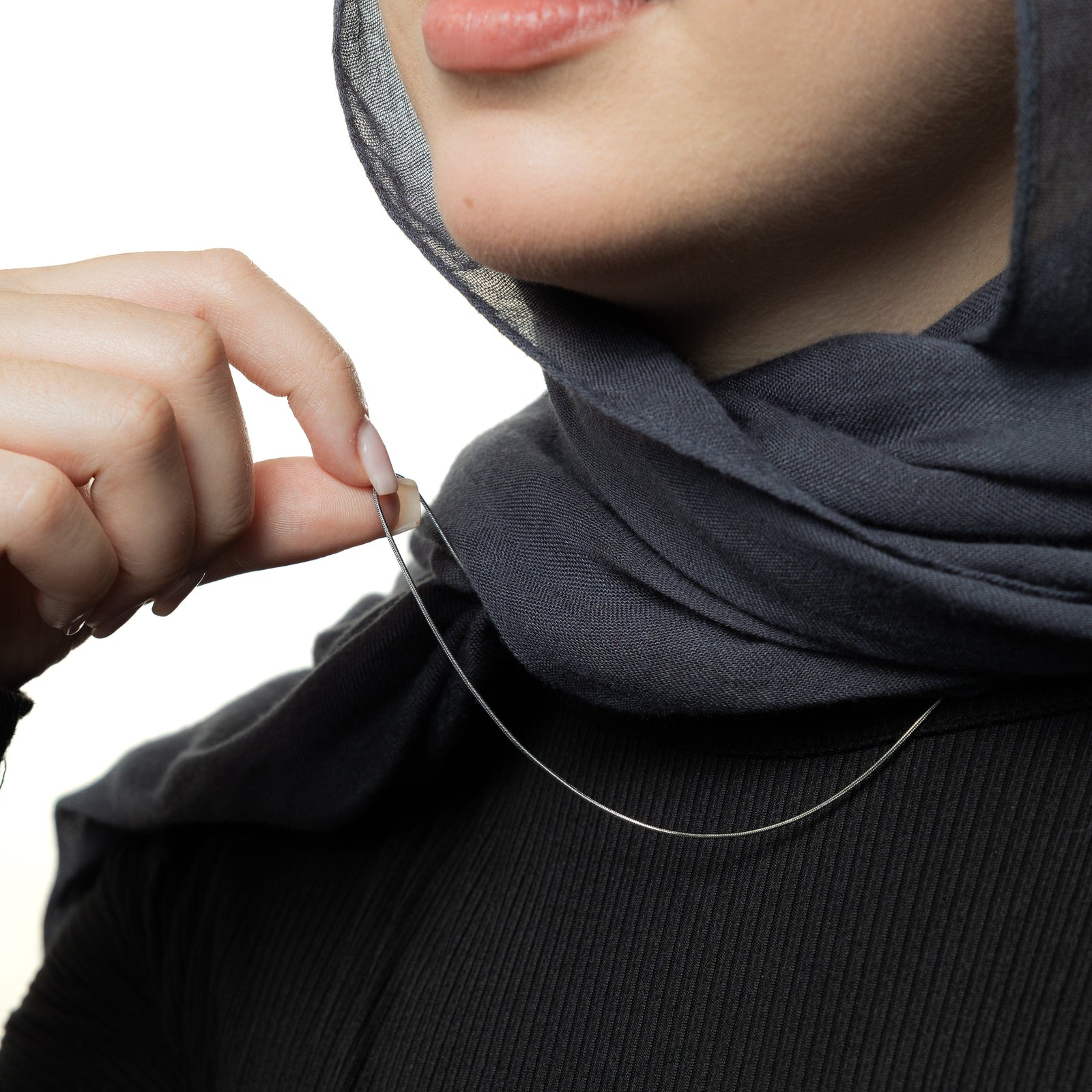 Close up of the silver Micro Harmony Chain as worn by the model.