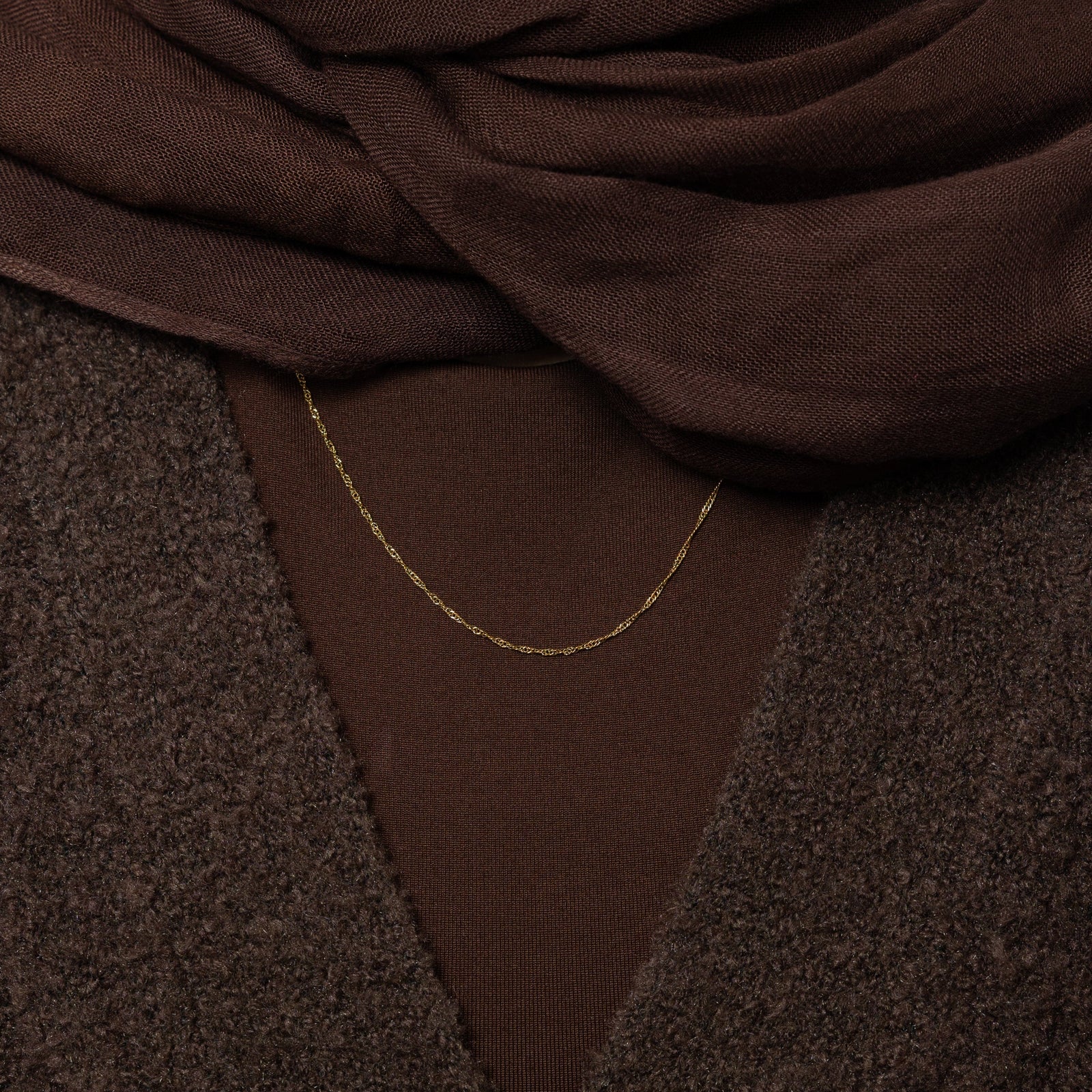 Close up of the Micro Twisted Chain against the dark fabric of the model's clothing.