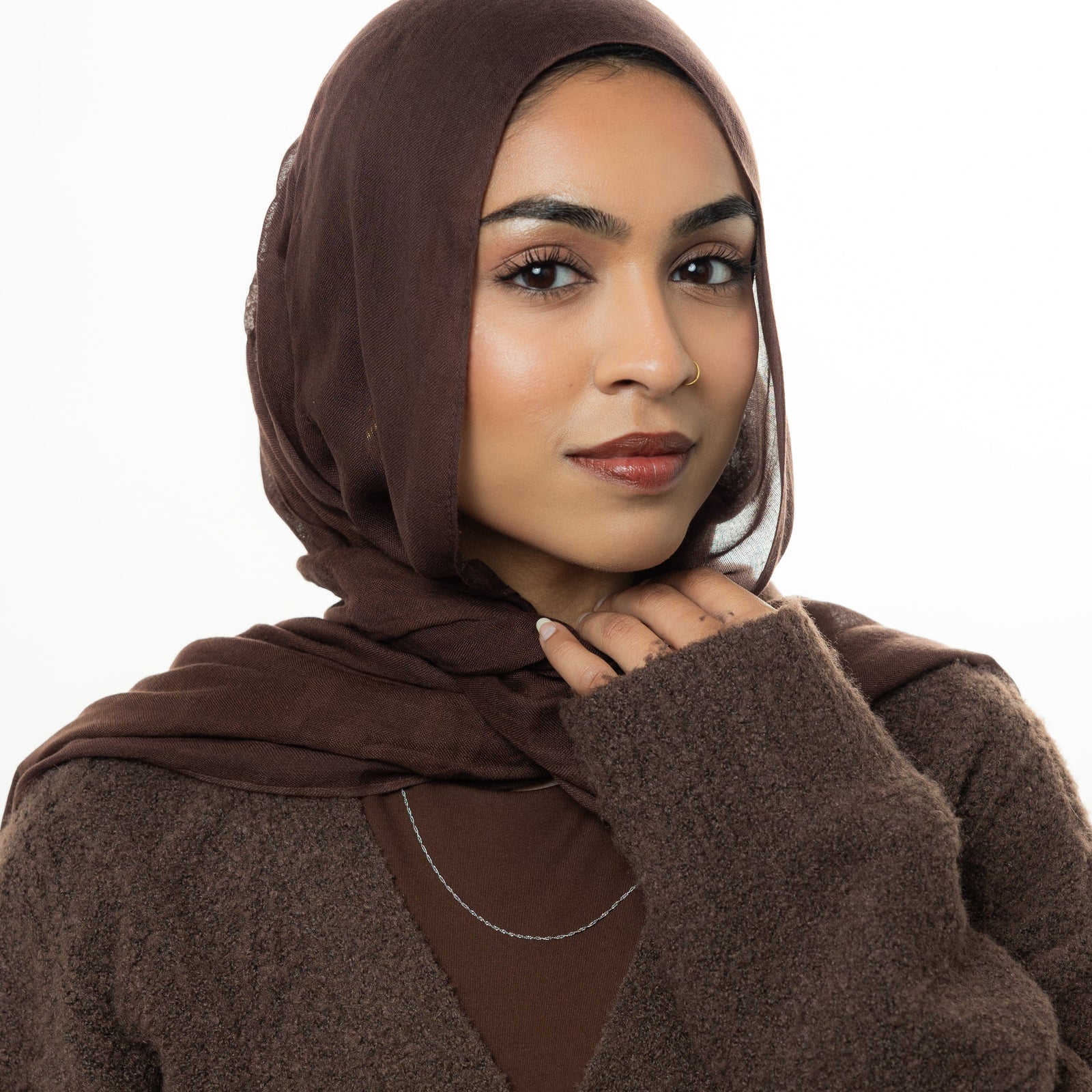 Photo of the model looking at the camera. The model is wearing the silver Micro Twisted Chain.