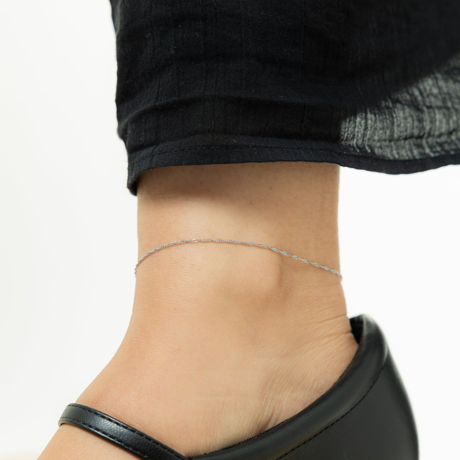 Close up of the silver Micro Twisted Anklet on the model's anklet.