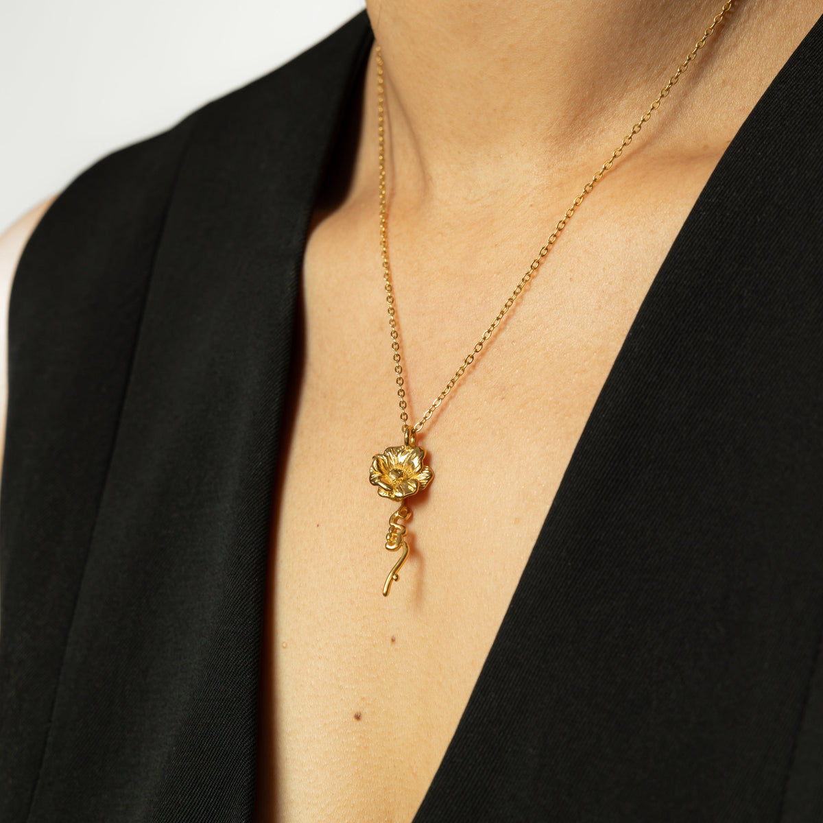 Close up of the gold It's Written' Anemone Necklace as worn by the model.